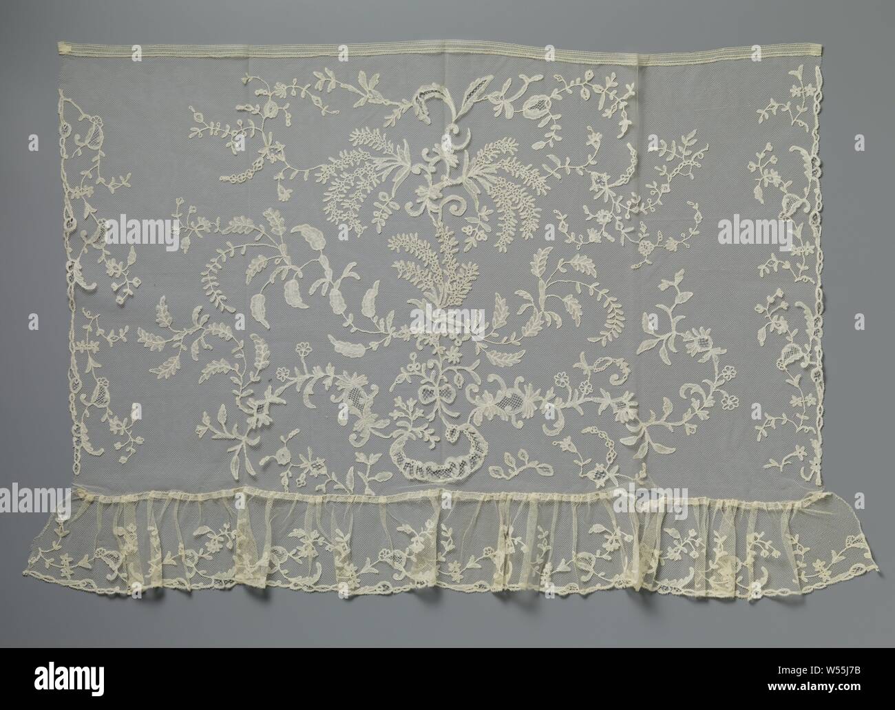Strip application side with mimosa branches, Strip natural color application side, bobbin lace appliqued on machine tulle. The pattern shows a row of mimosa branches waving to the right., anonymous, Belgium (possibly), c. 1890 - c. 1909, linen (material), h 10 cm × w 149 cm ×, 18.5 cm Stock Photo
