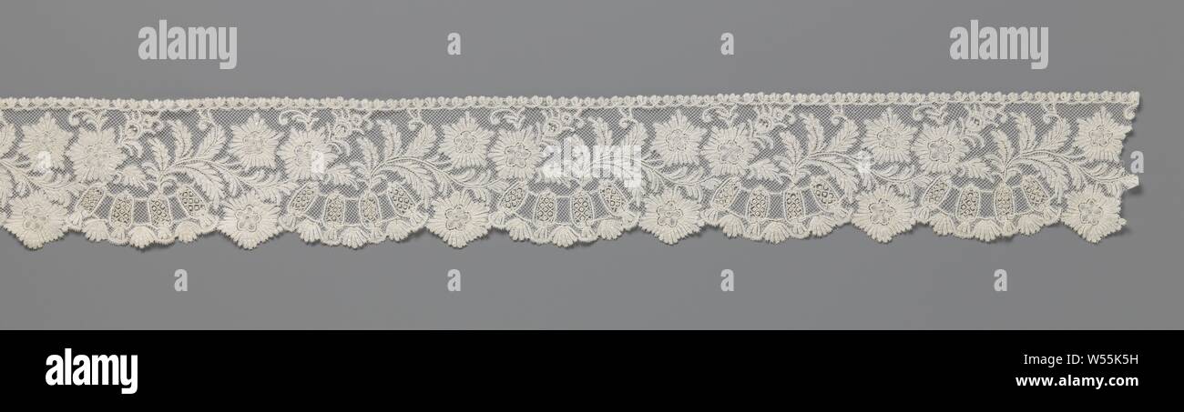 Strip of bobbin lace with goddess, A wavy branch with feathered leaves and three star-shaped flowers growing from right to left. One of the flowers is directed outwards and forms a small intermediate shell between larger ones, which are built up as a goddess arch or a piped collar with an open grid fill (needle edge). As a finishing touch to the fine mesh foundation (square meshes), a fine border of palm trees runs along the inside, applied as a lace head. Brabant Valenciennes side., Firma J. Minne-Dansaert, Brussels, c. 1880, linen (material), Brabant Valenciennes lace, l 520 cm × w 10.5 cm Stock Photo