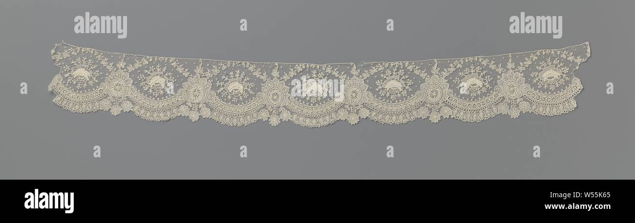 Strip of needle lace with hanging hearts, Strip of natural-colored needle lace: Brussels lace. The repeating pattern consists of large semicircular shells formed by connected c-volutes. Above each volute is a single rose with a halo of short twigs with berries. The switching points between the volutes are formed by oval medallions, which are decorated with a leaf crown. From the leaf crown comes a fine sling that runs with a bow over the rose to the next medallion. The scallop edge is formed by hanging heart-shaped leaves under the volutes, alternating with three hanging daisies below Stock Photo