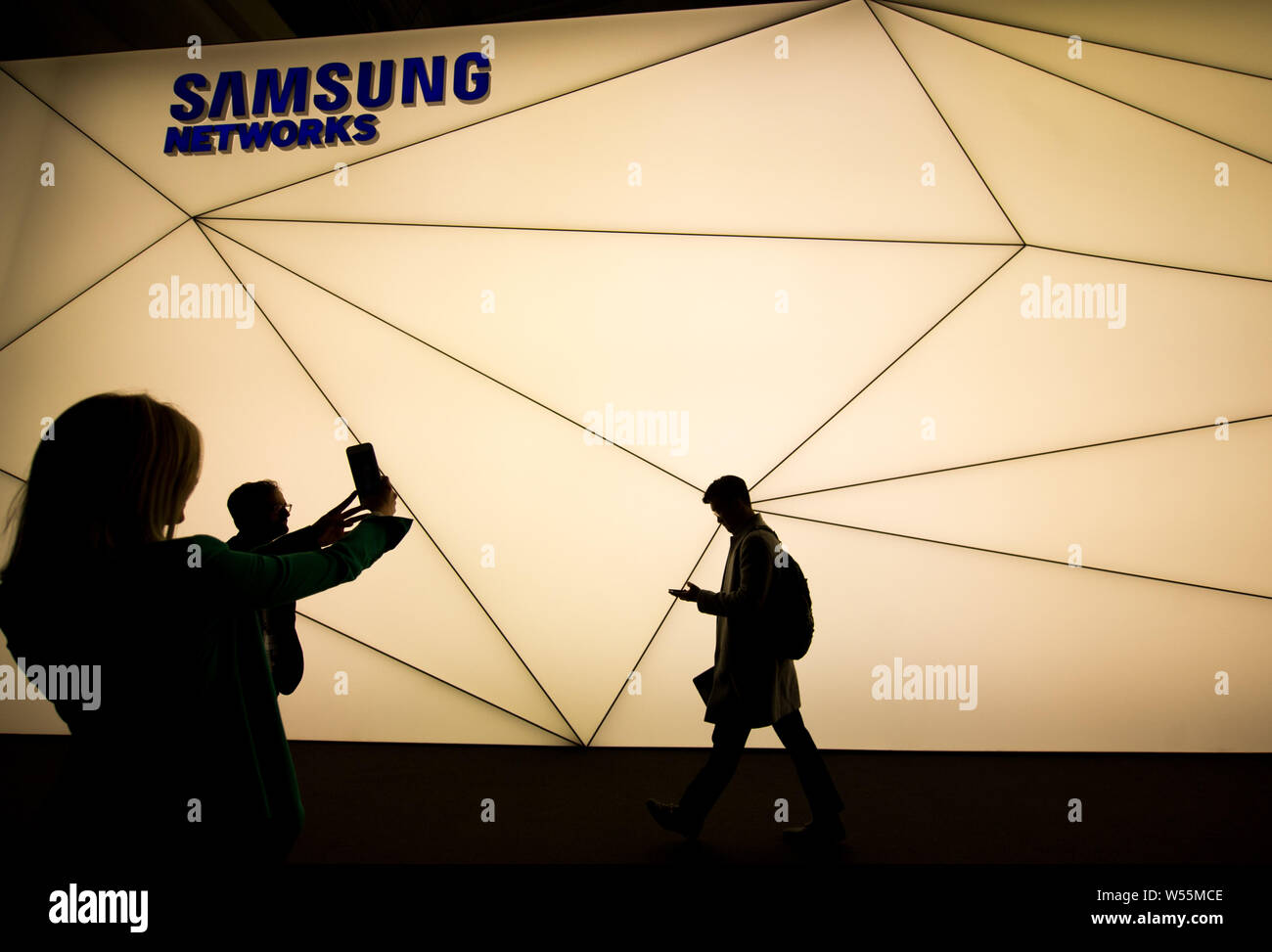 Visitors walk past the stand of Samsung Networks during the Mobile World Congress 2019 (MWC19) in Barcelona, Spain, 25 February 2019. Stock Photo