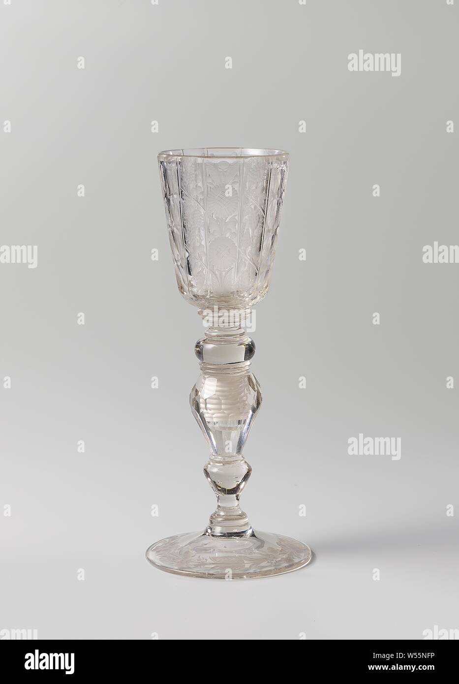 Cup with sunflowers, vines and circles, Vaulted foot. The trunk has a smooth and a facet-cut baluster, a knot and seven discs. Conical faceted cut with facet cut, rounded bottom. The trunk consists of two parts screwed together. At the bottom of the chalice a stylized leafy branch, on which three vertical bands, each composed of a strip of two sunflowers between two strips of grapes. The three bands are separated from each other by narrow strips with four circles. A continuous flower branch on the foot., anonymous, Bohemen, c. 1700 - c. 1725, glass, glassblowing, h 27.5 cm × d 11.3 cm Stock Photo