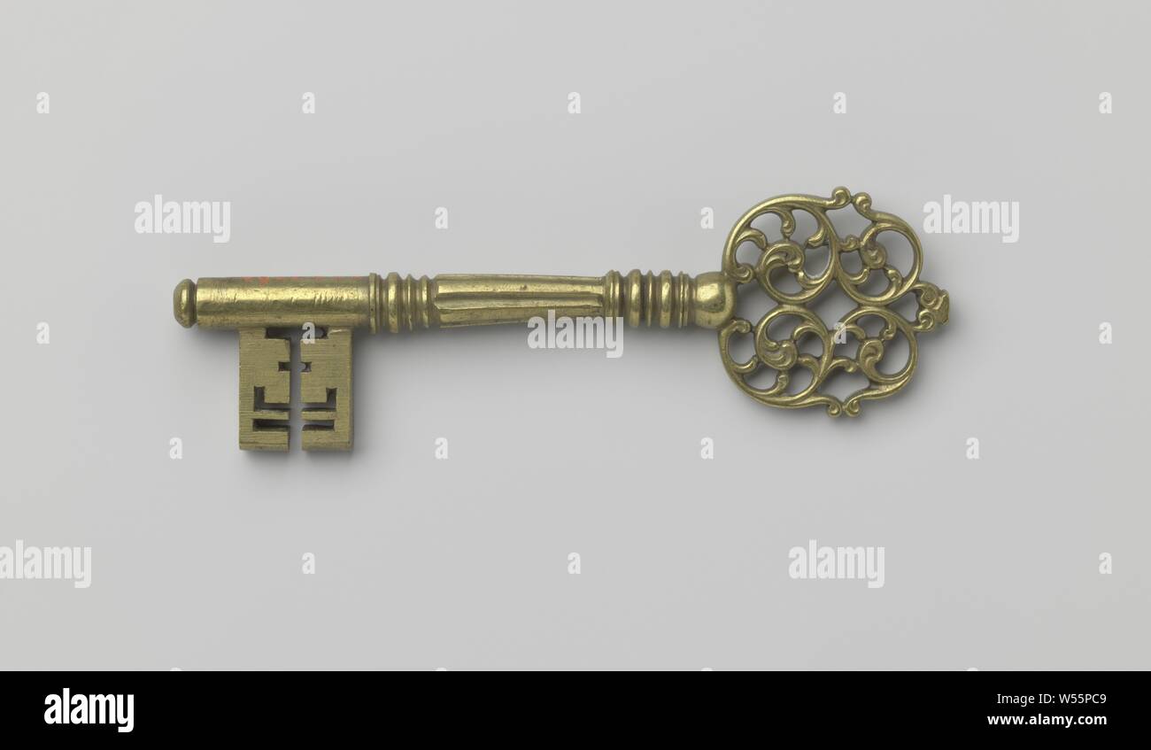 Key whose round handle is formed from tendrils' ornament. The shaft is baluster-shaped and fluted and continues past the beard and ends in a flat button., 1700 - 1725, copper (metal), l 12.5 cm × w 3.7 cm Stock Photo