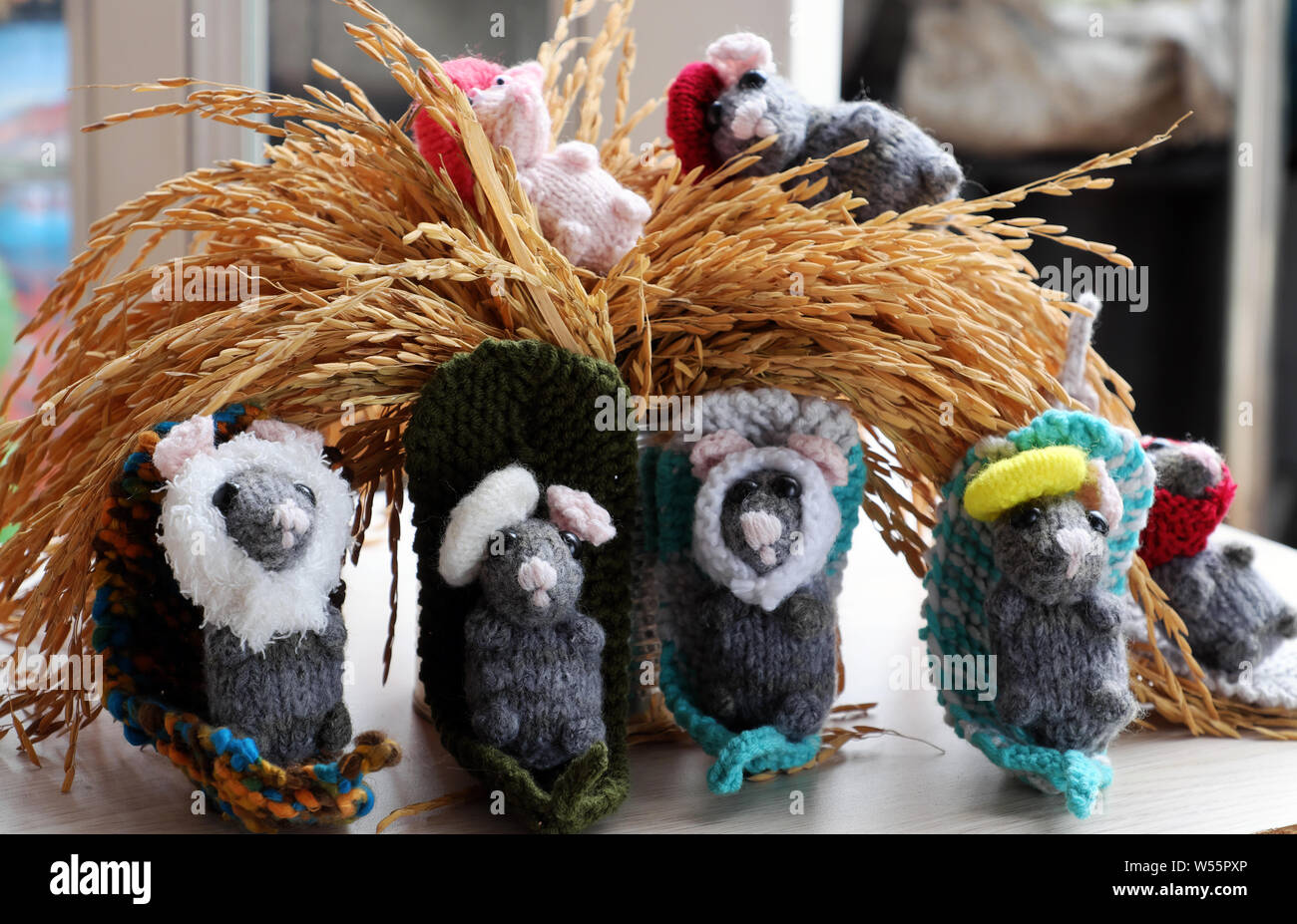 Colorful close up group of grey mice with sheaf of yellow paddy, tiny rats knit from yarn make funny concept Stock Photo
