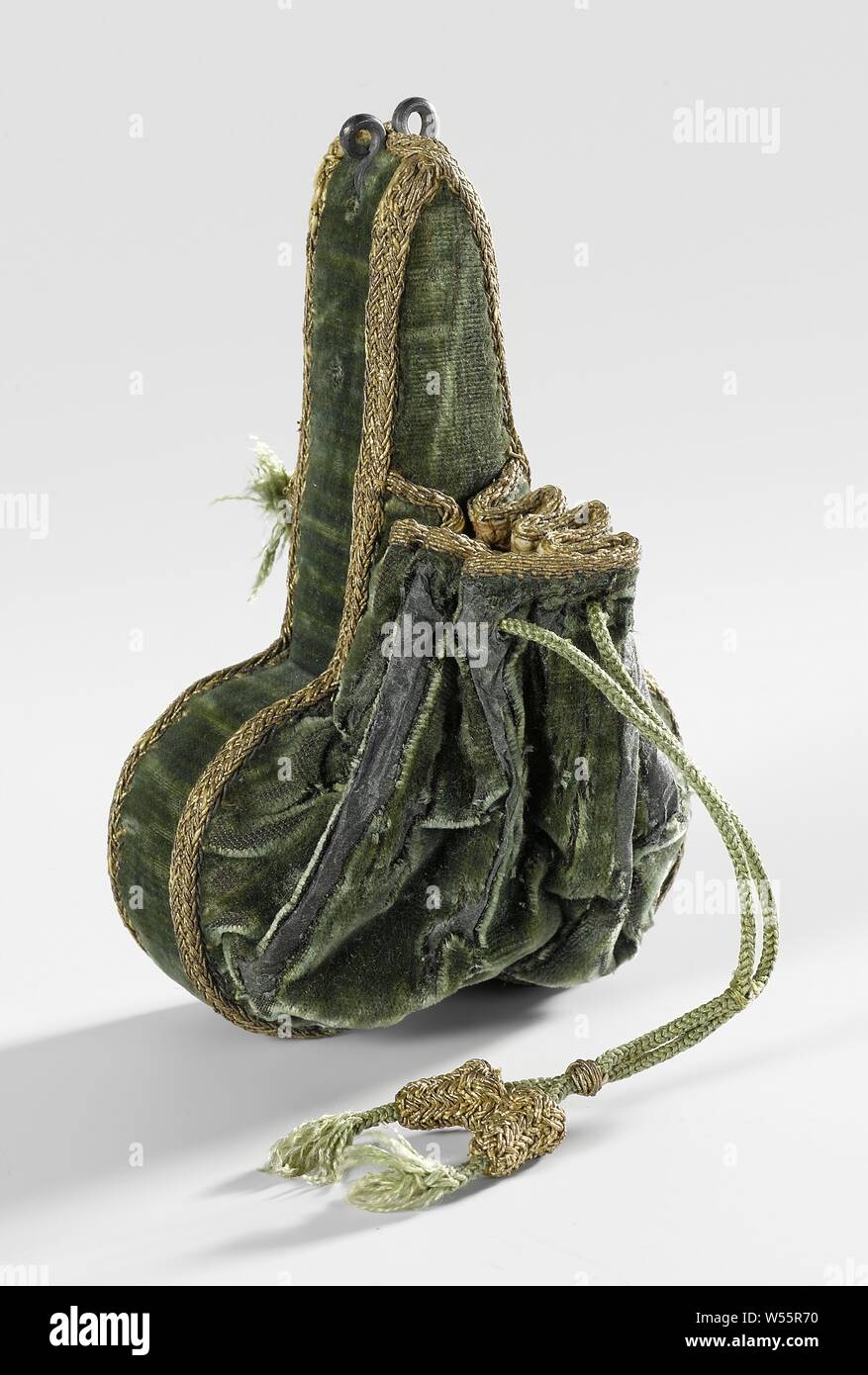 Purse of green velvet with drawstring and trimmed with gold thread on a box in the form of scissors (phallus?) made of ditto velvet and trimmings, with two metal eyes. At first glance, the object looks like a sheath for a pair of scissors with a small pouch on the front, lined with leather and provided with a drawstring of braided gold thread. However, the case cannot open and the pouch is so small that hardly any coins fit in it., anonymous, Netherlands (possibly), after 1580, bekleding, binnenwerk, passement, trekkoord, voering buideltje, ogen, forging, l 11 cm × w 7.5 cm Stock Photo