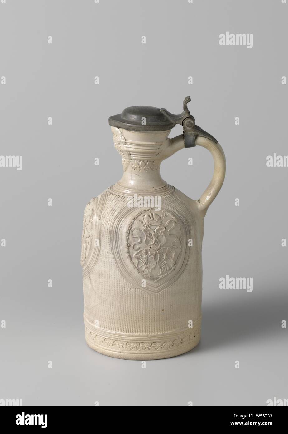 Jug with three coats of arms in medallions, Stoneware jug on a stand surface with a cylindrical body, round shoulder and narrow neck with pinched spout. The C-shaped ear is attached to the neck and shoulder. Profiles on the neck, shoulder and abdomen. The belly is covered with horizontally incised lines. Three times a engraved medallion with a printed and imposed medallion with three weapons (State Coat of Arms, family crest Von Merlan and the coat of arms of the city of Nuremberg) and the date '1596' were saved. Just above the foot a stamped band with leaf motifs. A mask embossed on the neck Stock Photo