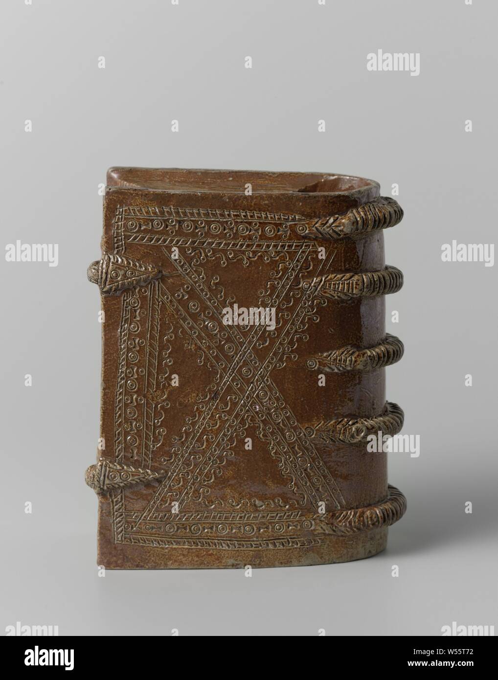 Beaker Drinking vessel in the shape of a book, Stoneware drinking cup in the shape of a book with two cleats and five ribbed straps on the back. At the top, on the side of the back, a hole to drink out. On the cover decorative bands with stamped ornaments, which together form a cross in a rectangle. Raeren., anonymous, Raeren, c. 1600 - c. 1615, stoneware, glaze, engobe, vitrification, h 16.4 cm × w 13.5 cm × t 7 cm Stock Photo