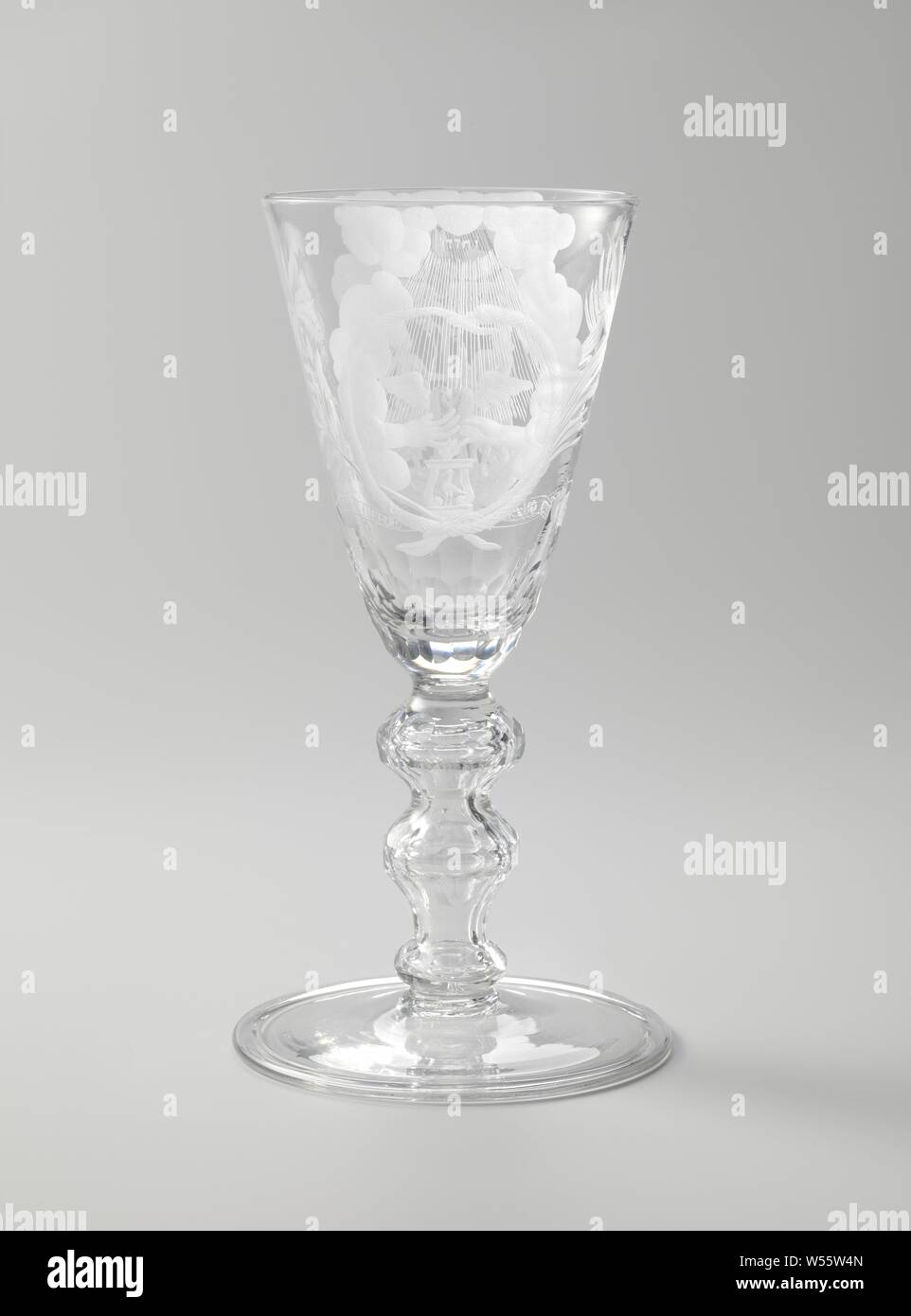 Marriage glass, Goblet with a man and a woman at an altar and the inscription: GOD'S LOVE FLAME FEED OUR STEM, Flat foot. Faceted baluster stem with knots and a bubble. On the conical cup on one side a winged heart that holds two hands above an altar. Around it a snake that bites its tail, above it the name of God. On the other side a man and a woman reach out to each other above an altar with XXV on it, a tree on top, a winged heart above it. Around it a snake that bites its tail. Furthermore crossed palm and laurel branches and a banderole with the inscription: GOD'S LOVE FLAME FEED OUR STEM Stock Photo