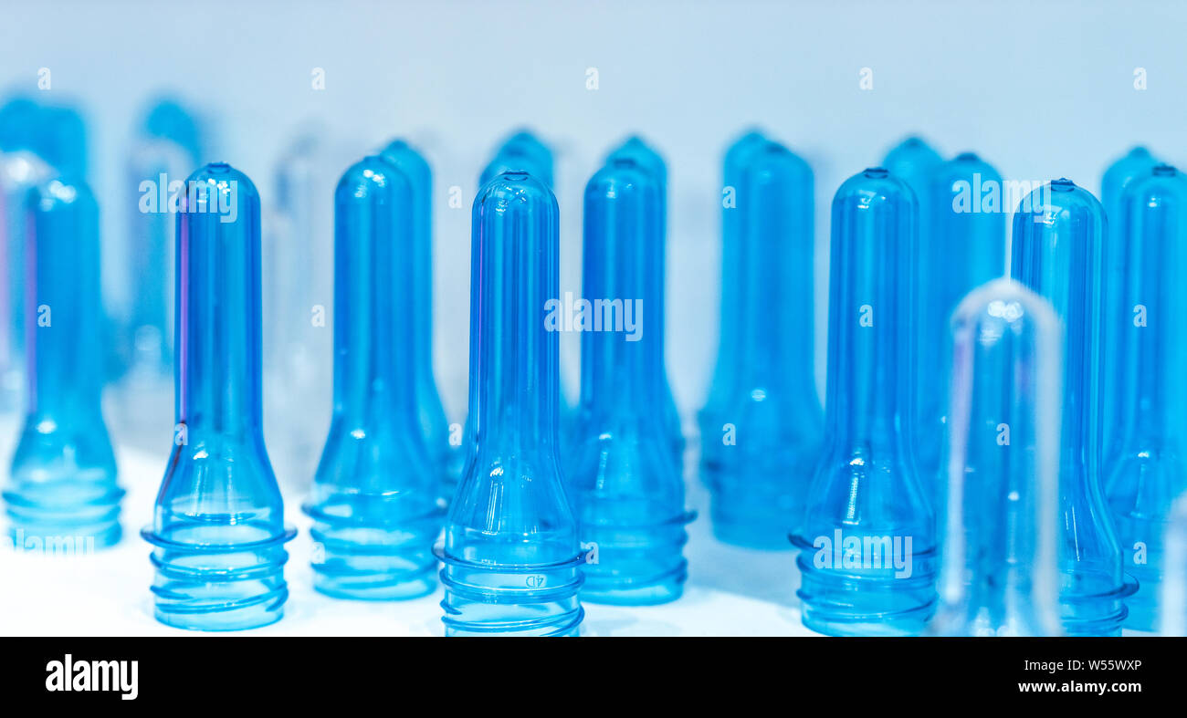 PET bottle preforms before blow molding, filling and labeling process. Blue PET bottle preform for beverage industry. Raw material for PET bottle Stock Photo