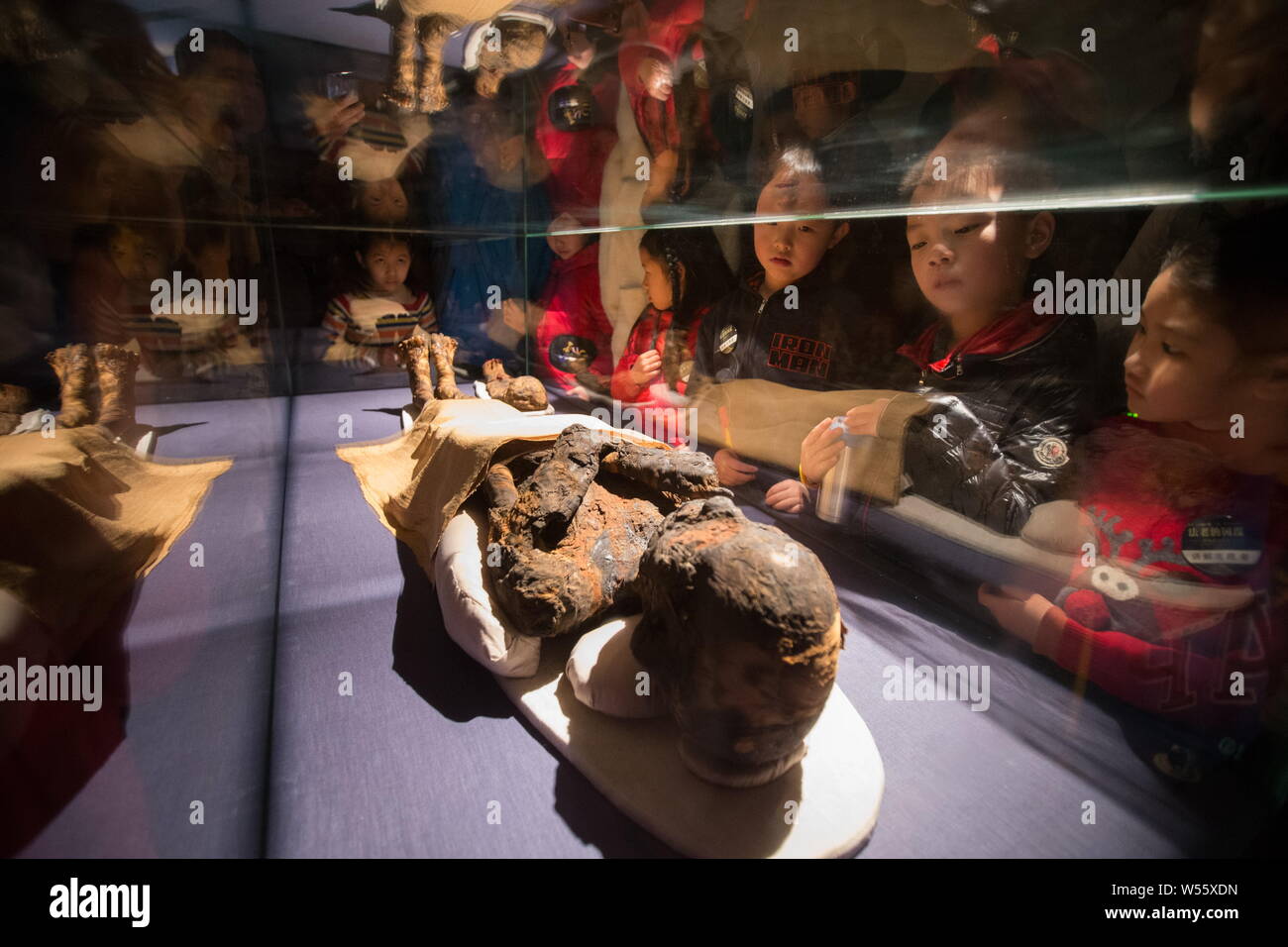 People look at a mummy displayed in an exhibition of ancient Egyptian civilization at Zhejiang West Lake Gallery in Hangzhou city, east China's Zhejia Stock Photo