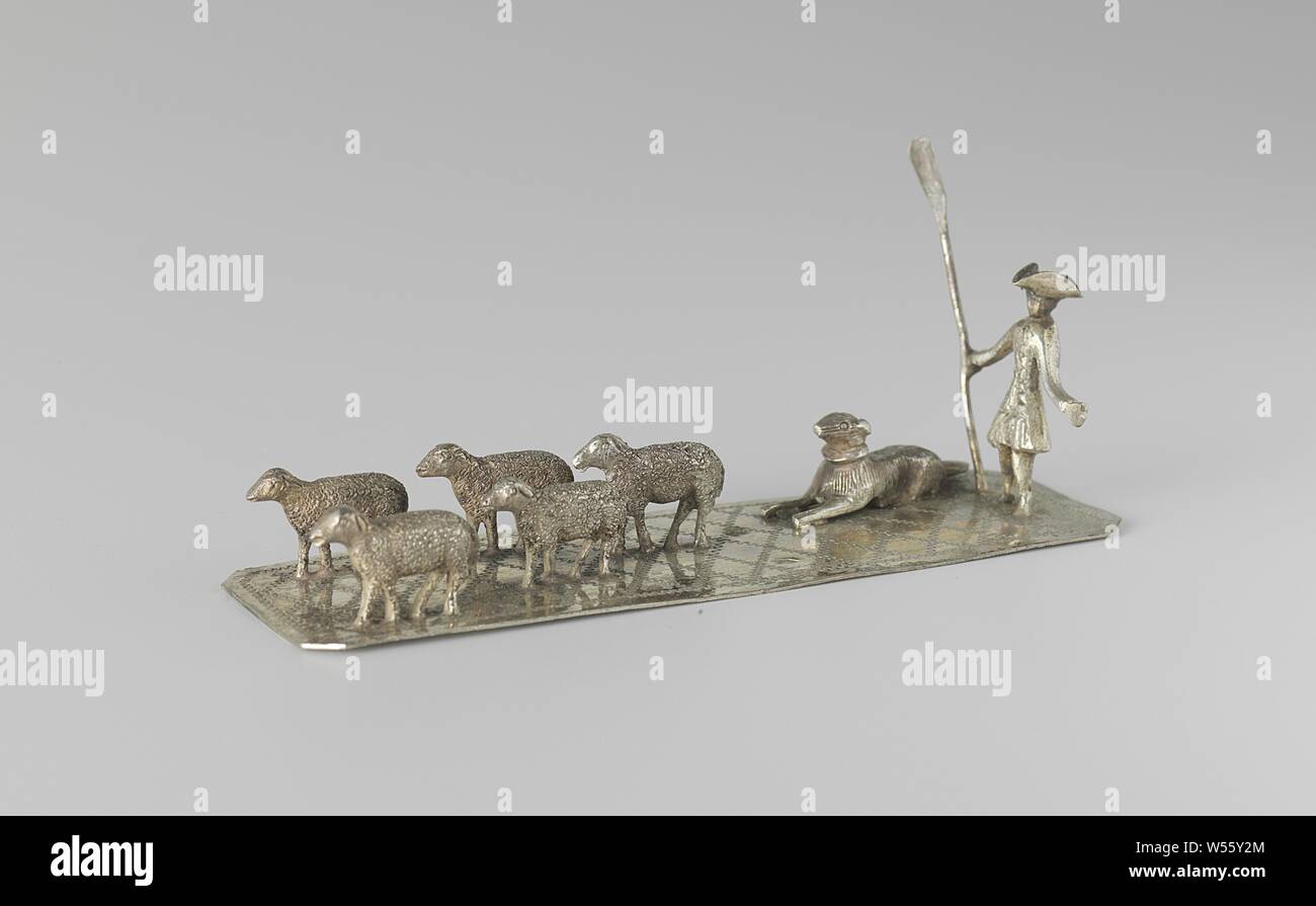 Shepherd with herd, On an elongated plate stands a man with a stab and a stick in his right hand. To the right is a dog. Five sheep are walking for the man and the dog. A diamond pattern is engraved on the plate. The image is marked with a dolphin and a master mark., Herding, herdsman, herdswoman, shepherd, shepherdess, cowherd, etc., herd, flock, Arnoldus Wilhelmus Flemminks, Nijmegen, c. 1858 - c. 1898, silver (metal), l 11.1 cm × w 3.3 cm × h 4.6 cm × w 49.89 Stock Photo