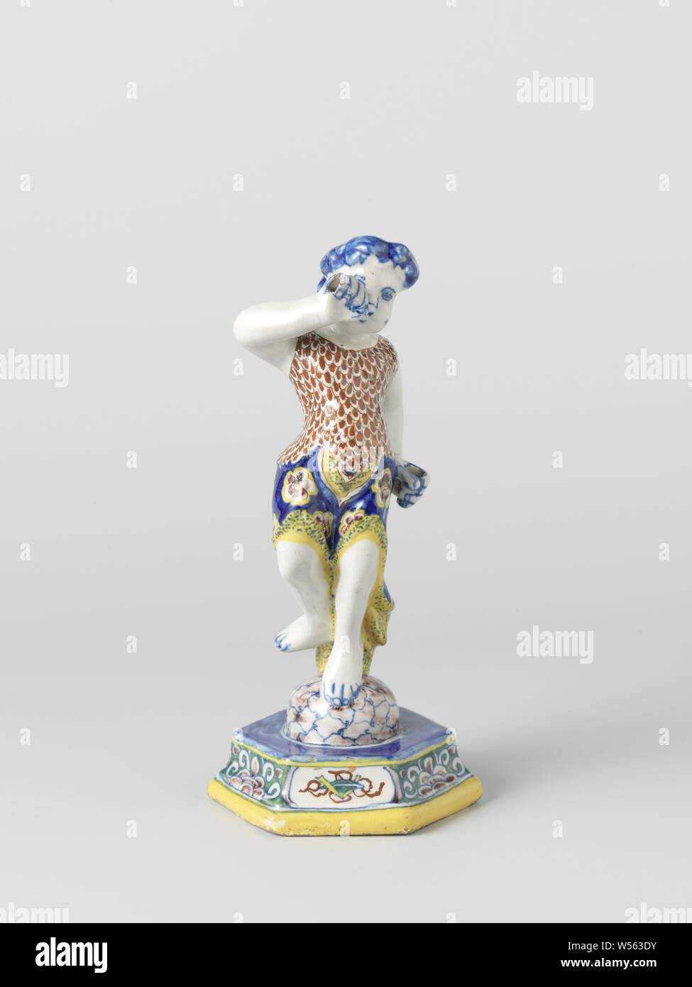 Multicolored painted decorative object from faience, Human figure from faience. Multicolored decorated. Probably represents the trumpet-blowing genius., anonymous, Delft, c. 1720 - c. 1750, h 22.5 cm × d 10.6 cm Stock Photo