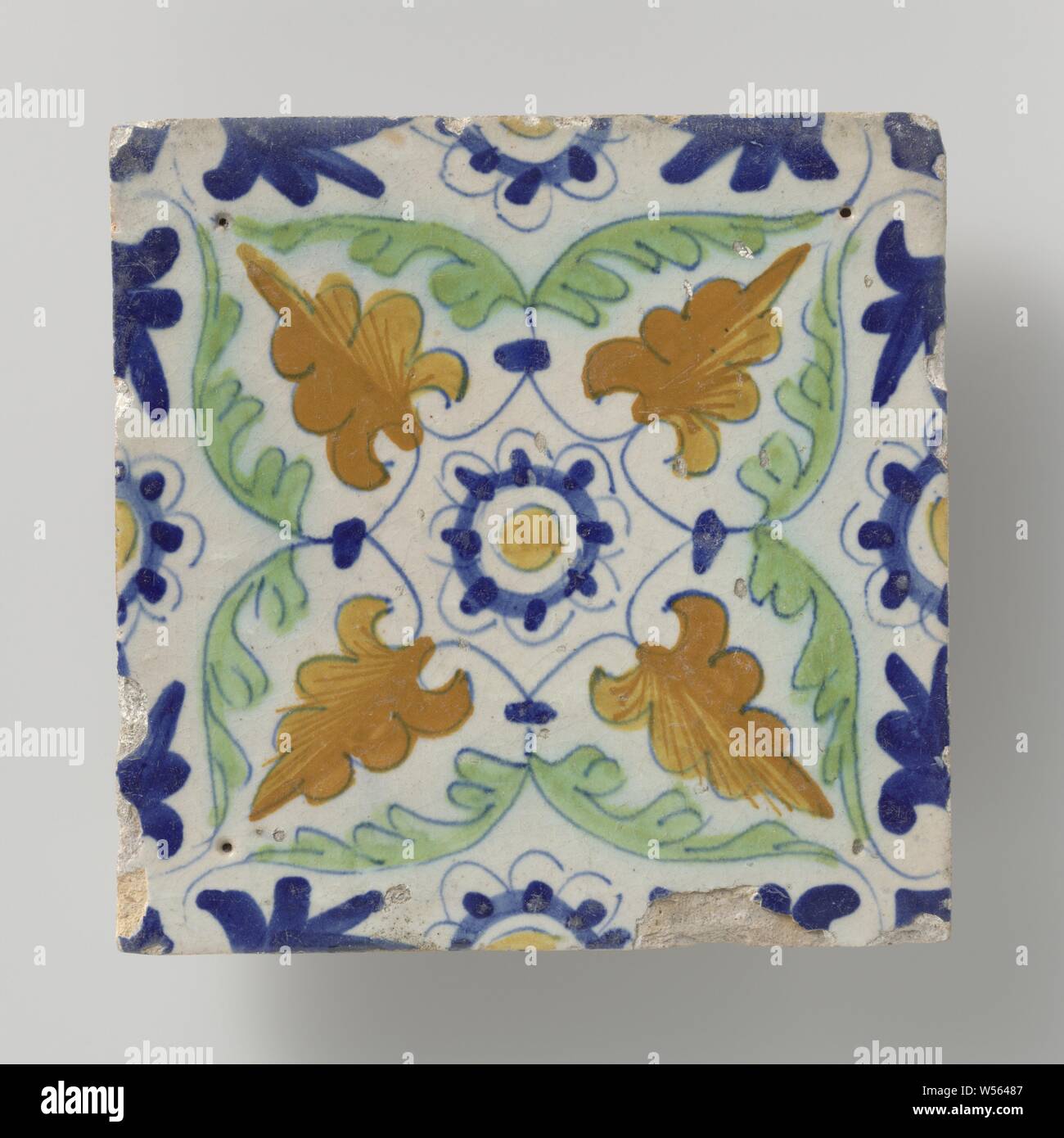 Tile, Tile with a multicolored (blue, green and orange) rosette surrounded by four leaves to the corners. Along the edges, half rosettes., anonymous, Netherlands, 1600 - 1630, earthenware, tin glaze, h 13.4 cm × w 13.2 cm × t 1.4 cm Stock Photo