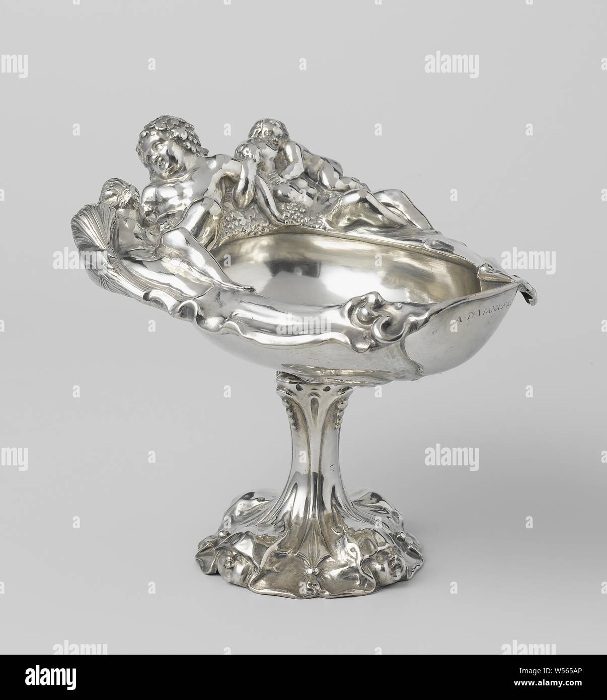 Tazza (footed drinking cup), Driven silver coupe, Driven silver coupe. The asymmetrical cuppa is decorated with lobster ornament. On the edge the figures of Bacchus, Ceres and Venus with Amor, auricular ornament, lobe style, ornament, (story of) Bacchus (Dionysus), Liber, (story of) Ceres (Demeter), (story of) Venus (Aphrodite), (story of) Cupid, Amor (Eros), Adam van Vianen (I), Utrecht, 1621, silver (metal), h 15.6 cm × l 17.8 cm × w 13.9 cm Stock Photo