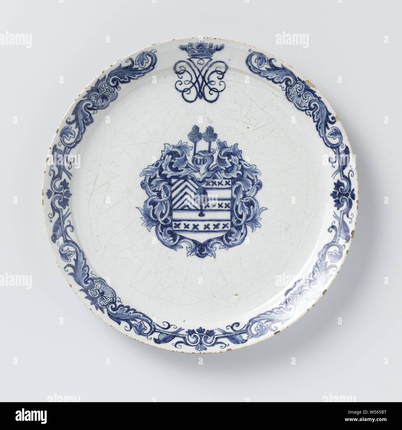 Plate painted with an unknown weapon, possibly Van Egmond, Pottery plate painted in blue on tin glaze with an unknown weapon in the shelf, possibly from a member of an unknown family Van Egmond. A crowned mirror monogram J.V.E. The border decorated with sheet metal., anonymous, Delft, 1718, d 21.7 cm Stock Photo