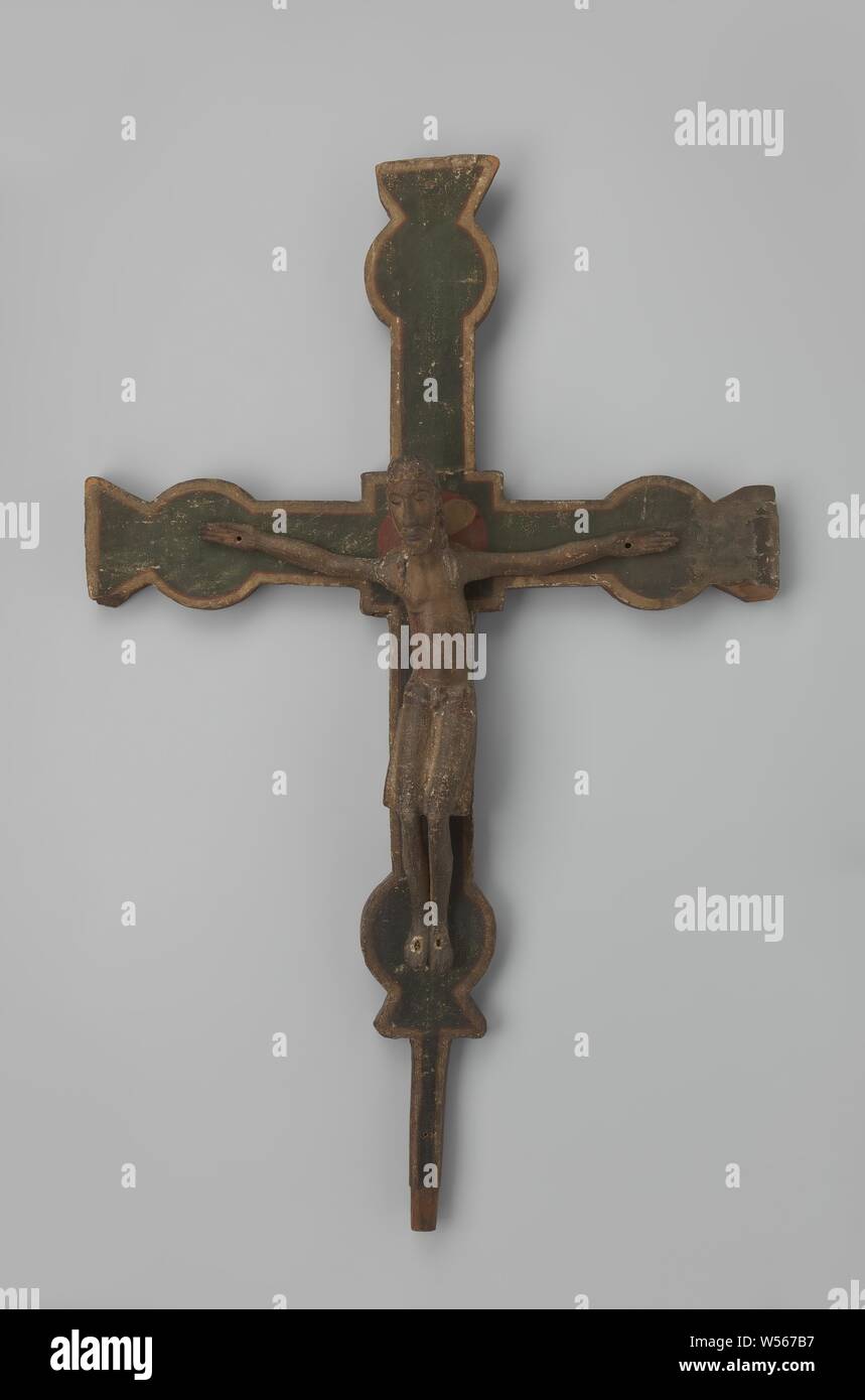 Cross on which Christ figure with knees sagged to the left and feet placed side by side and practically horizontal arms. The corpus shows knees sagged to the left for a moment, the feet stand side by side, the arms are almost horizontal. From the head bent slightly to the left with its hair separated, tresses fall over the shoulders, the eyes are closed. The loincloth with belt hangs to the knees. The beams of the crosswood widen into a square at the intersections, they end in a circular widening, merging into an inwardly tapered projection, the lower part changes into a narrow inlet piece Stock Photo