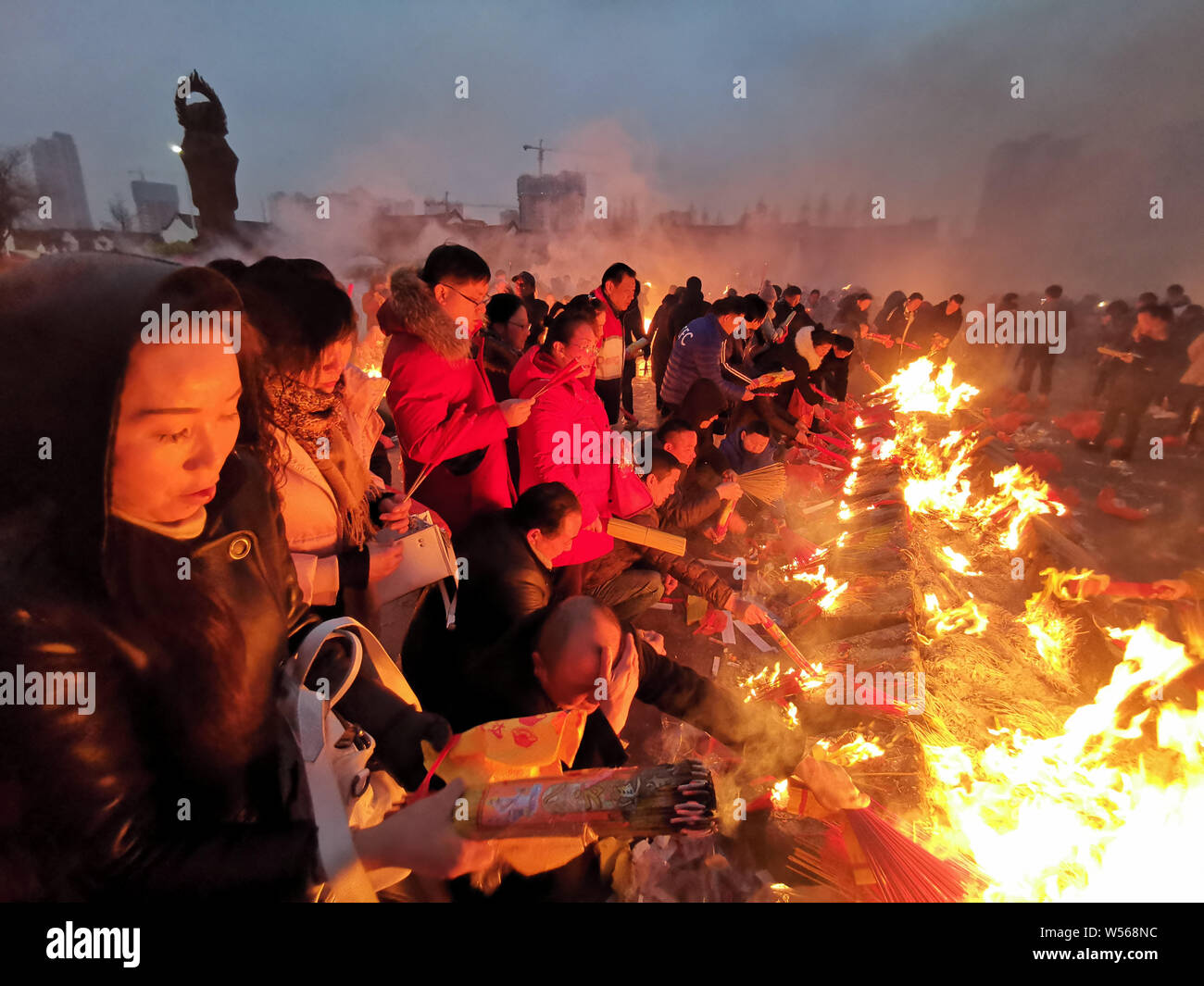 Chinese worshippers burn incense sticks to pray for wealth and ...