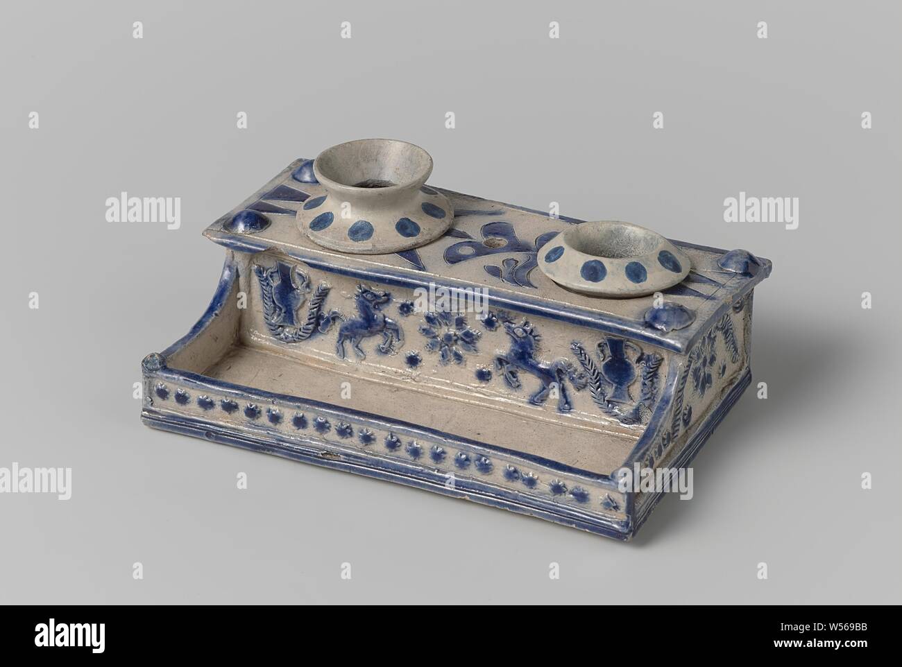 https://c8.alamy.com/comp/W569BB/ink-stand-with-horses-vases-and-flowers-ink-set-of-stoneware-with-a-pen-tray-and-two-holders-for-the-inkwell-and-the-sand-shaker-partially-covered-with-cobalt-blue-the-front-and-back-with-a-relief-decoration-of-a-printed-and-superimposed-flower-flanked-by-prancing-horses-and-two-piece-vases-surrounded-by-a-festoon-an-incised-stylized-flowering-plant-on-the-top-a-modeled-rivet-on-each-corner-westerwald-anonymous-westerwald-c-1750-c-1799-stoneware-glaze-cobalt-mineral-vitrification-h-43-cm-w-142-cm-d-9-cm-W569BB.jpg