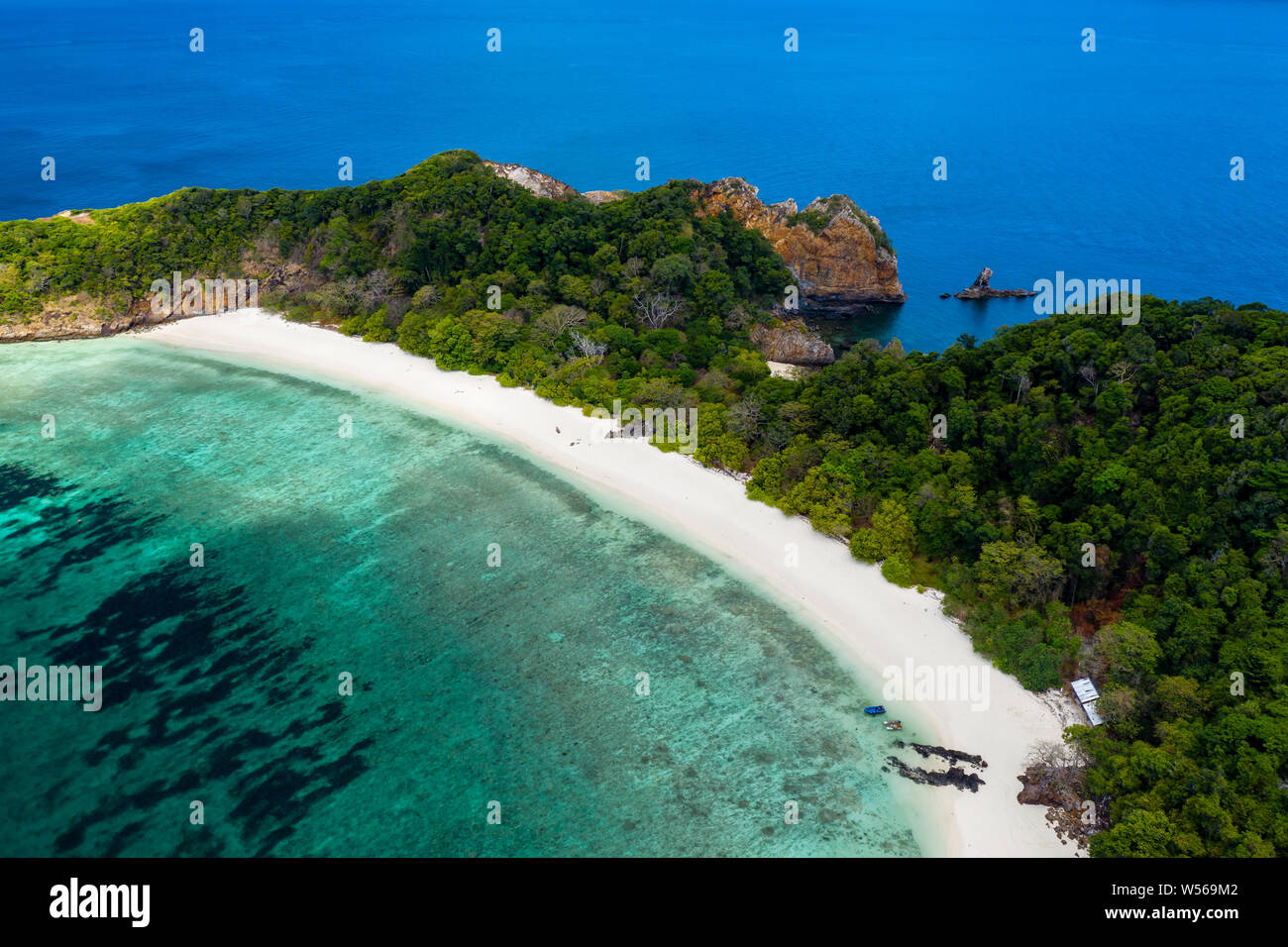 Aerial drone view of a lush, green tropical island with sandy beach ...