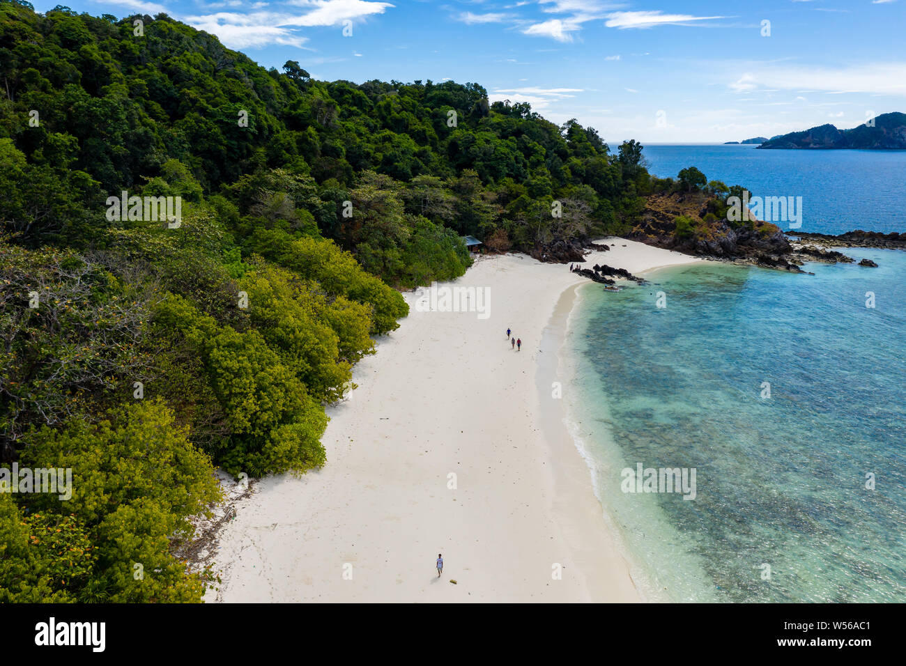Aerial drone view of a lush, green tropical island with sandy beach ...