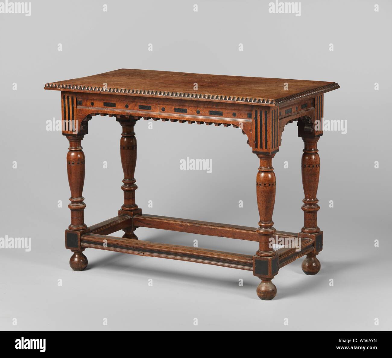 Table with vase-shaped legs, connected by bottom rails, Table of walnut on legs with vase-shaped sections and houses and connected by bottom rails. The top line has a hollowed tooth strip, which runs with round support pieces. The rules are well-founded and, like the houses and swellings of the legs, decorated with ecclesiastical frames and bands. The magazine has a bead list., anonymous, Netherlands, 1640 - 1660, wood (plant material), walnut (hardwood), ebony (wood), h 78.0 cm × w 104.0 cm × d 56.5 cm × w 21.4 kg Stock Photo