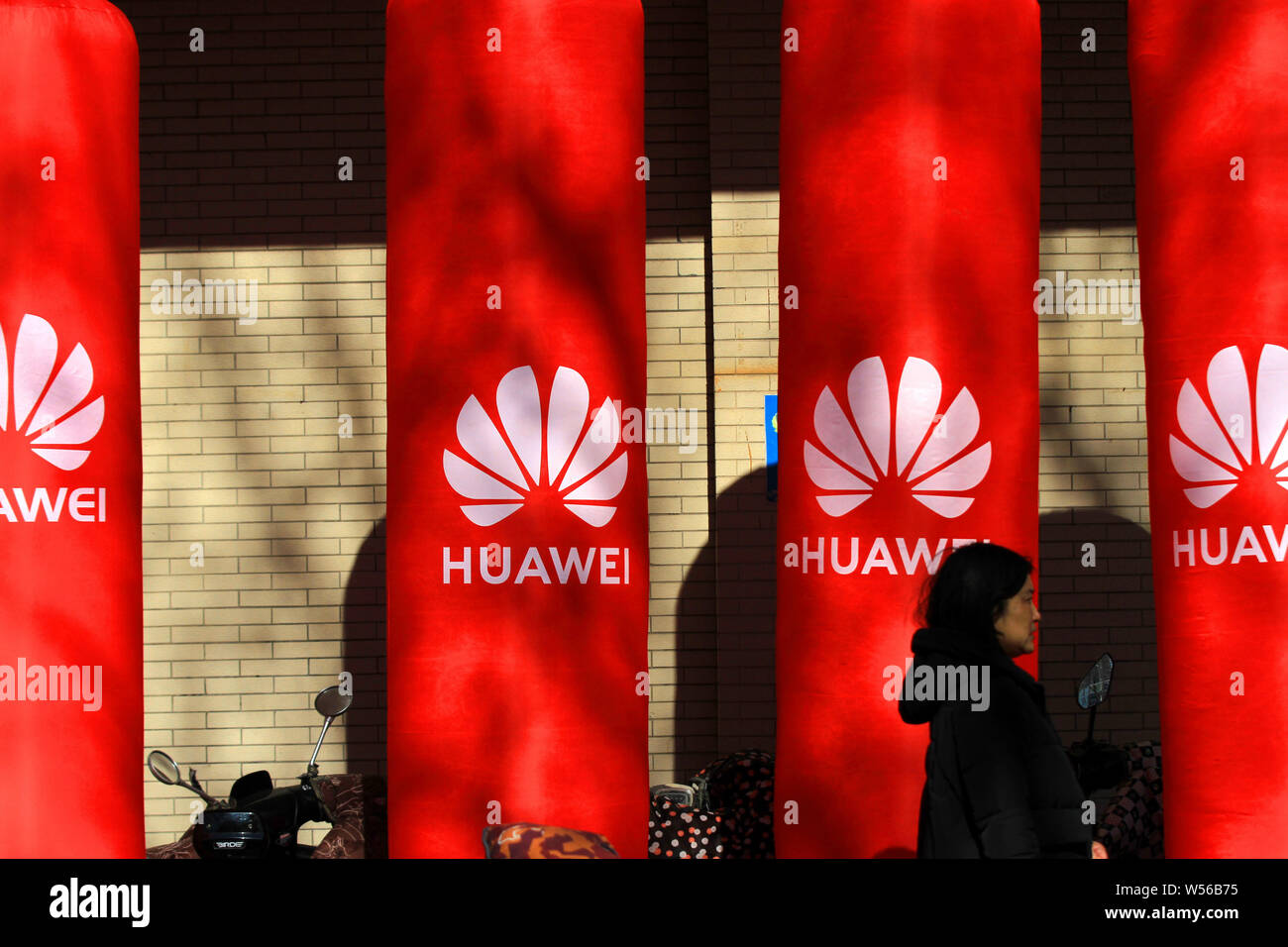 --FILE--Pedestrians walk past an advertisement for Huawei in Huai'an city, east China's Jiangsu province, 26 January 2019.   Huawei Technologies said Stock Photo