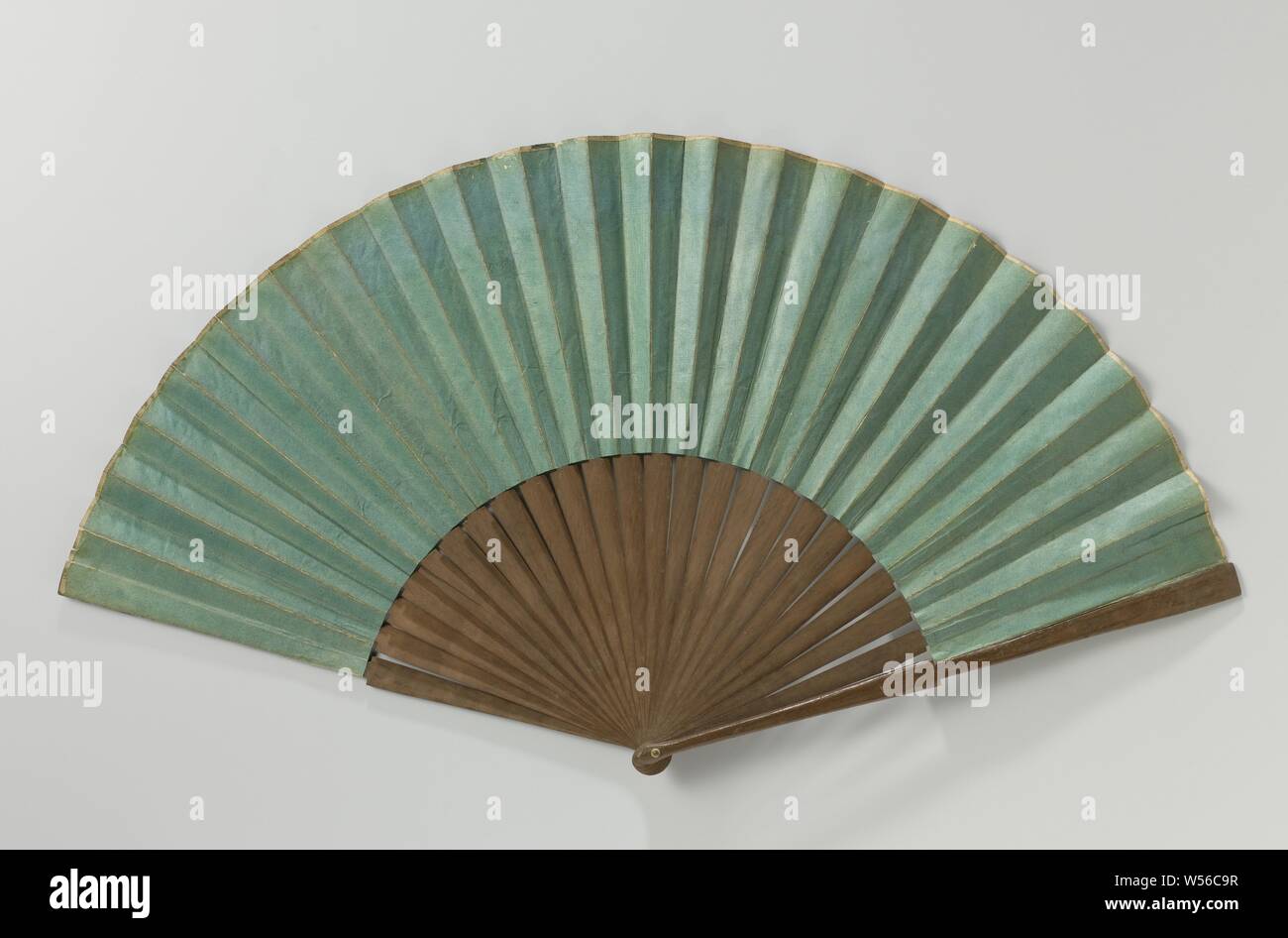 Folding fan with double leaf of green painted paper on an unadorned wooden frame, Folding fan with double leaf of green painted paper on an unadorned wooden frame. 24 contiguous legs. In addition to this specimen, the Van Eeghen collection (now at the KOG) contains a number of these simple fans with a sheet of plain green paper. Although several specimens have been preserved and it could be deduced from this that these impellers were used fairly generally, to date, virtually nothing is known about their origin or use. Only one mention of this specific type of impellers is known and can be Stock Photo