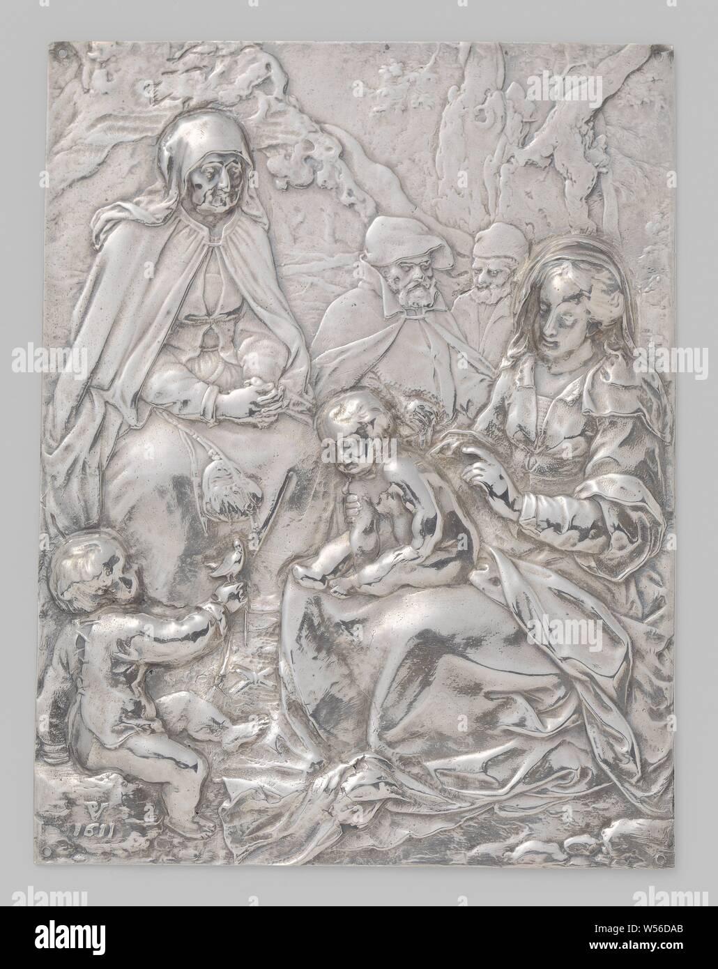 Holy Family Holy family, Rectangular, silver plaque. In the right foreground Maria is seated with the child in her lap. For her the little John the Baptist, who shows Jesus a bird with the right hand. On the second plan Elisabeth and further to the background Joseph and Zechariah. Landscape with trees and rocks, Mary, the Christ-child and John the Baptist, Elisabeth and Zacharias present, Paulus Willemsz. van Vianen, Praag, 1611, silver (metal), copper (metal), wood (plant material), h 12.7 cm × w 9.7 cm × w 2.25 cm Stock Photo