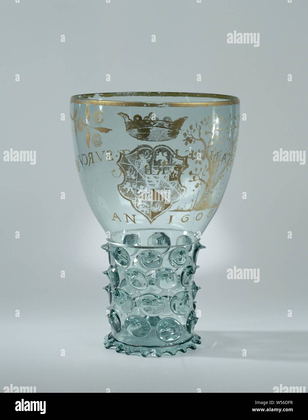 Roemer with the arms of Prince Maurits and the inscription: TANDEM.FIT. SVRCULUS ARBOR, Large rummer with stand ring pulled out in drops. Inserted bottom. The trunk, set with four staggered rows of buds, blown as a whole with the wide, slightly curved chalice. The transition from the stem to the chalice is indicated by a smooth wire. The chalice depicts the coat of arms of Prince Maurice in engraved gold gilt. Under the weapon 'AN 1606'. Next to the coat of arms a truncated tree, from which three shoots with orange cones sprout, on the other side of the crown a branch with three roses. On Stock Photo