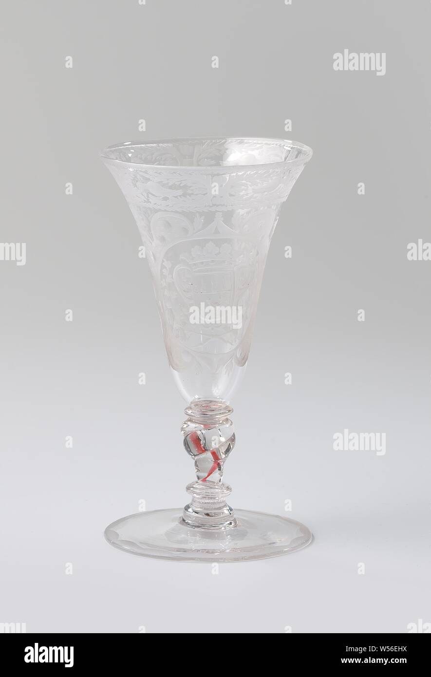 Chalice with the arms of the Van Beuningen family, Chalice made of clear, colorless glass. Flat foot. The twisted, baluster-shaped trunk has a red spiral, a bubble and three mereses. The trumpet-shaped bowl has a rounded bottom. On the chalice, in a cartouche consisting of volutes with matted surfaces with dots and circles, surrounded by leafwork, is an oval medallion with the crowned family crest Van Beuningen, flanked by two branches that are tied together at the bottom. Along the mouth edge a band with symmetrical leafwork and flower sprays and two pigeons between a serrated edge and a Stock Photo
