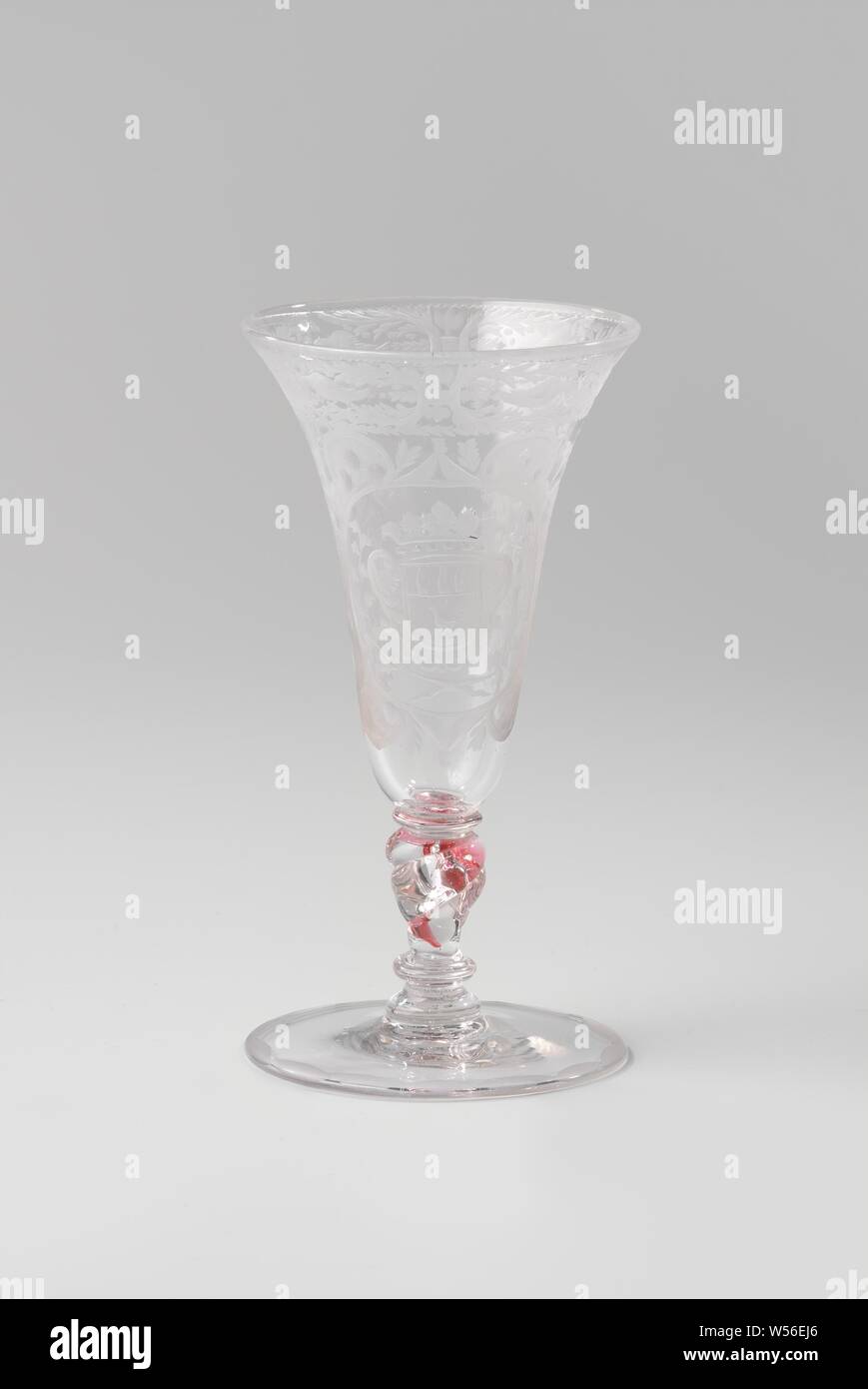 Goblet with the arms of the Van Beuningen family, Goblet of clear, colorless glass. Flat foot. The twisted, baluster-shaped trunk has a red spiral, a bubble and three mereses. The trumpet-shaped bowl has a rounded bottom. On the chalice, in a cartouche consisting of volutes with matted surfaces with dots and circles, surrounded by leafwork, is an oval medallion with the crowned family crest Van Beuningen, flanked by two branches that are tied together at the bottom. Along the mouth edge a band with symmetrical leafwork and flower sprays and two pigeons between a serrated edge and a stylized Stock Photo