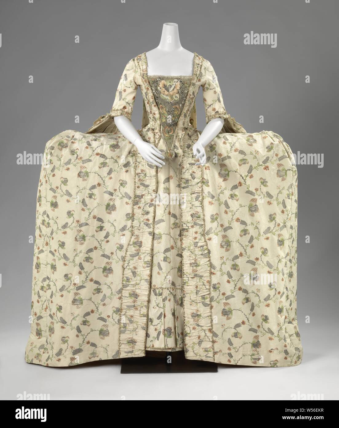 Sack-Back Gown with a Half Skirt (robe à la française) Overcoat with half skirt or robe à la française, Dress of silk brocade, with a cream colored fond, on which multicolored sides, golden and silver flowers, consisting of an overcoat (a) and a half skirt or tablier (b). Lined with yellow silk. Model: 'Grande Parure', Amsterdam, anonymous, Netherlands (possibly), c. 1765 - c. 1775, japon, voering, l 152 cm l 103 cm Stock Photo