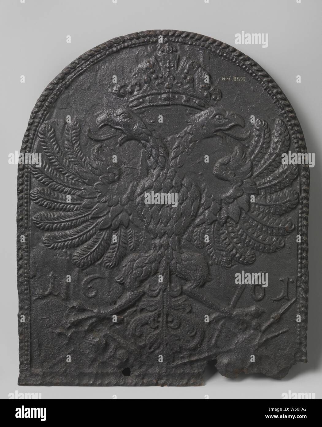 Fire plate with crowned double-headed eagle, Fire plate made of cast iron, with a semicircular top. In the middle is a double-headed eagle with spread wings and claws. Above that a crown. Next to the eagle the year 1661. The whole is framed by pearl border and decorative border., anonymous, Germany, in or after 1661 - 1675, iron (metal), founding, h 69.0 cm × w 58.0 cm × w 24 kg Stock Photo