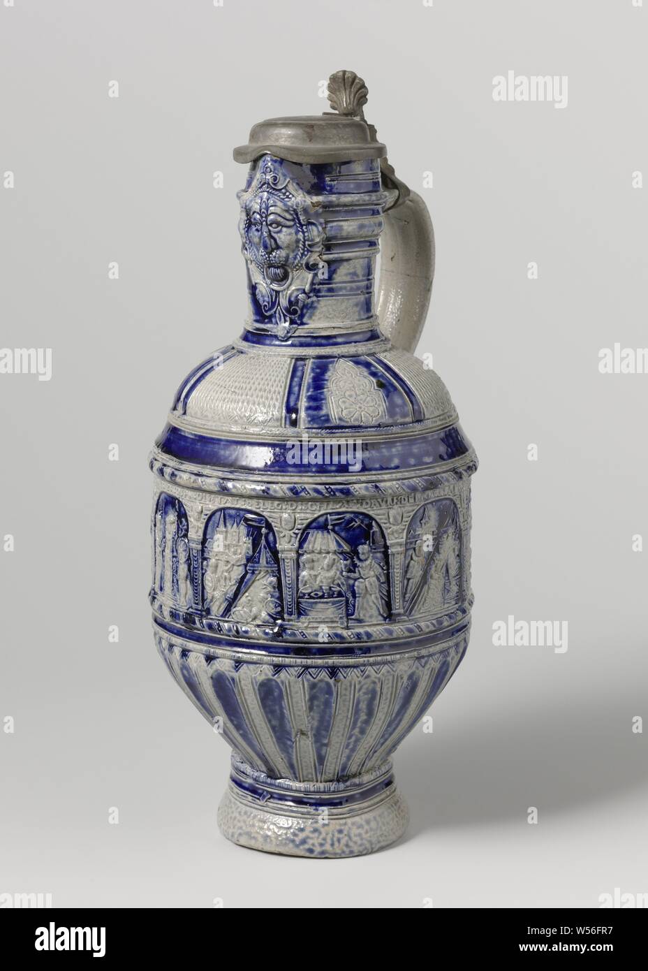 Jug with scenes from the life of Judith and Holofernes, Can of stoneware on high feet with a cylindrical body, round shoulder and narrow neck with pinched spout. The C-shaped ear is attached to the neck and shoulder. Profiles on the neck, abdomen and foot. Partially covered with cobalt blue. On the cylindrical part of the abdomen nine representations, of which the first three are double, from the life of Judith and Holofernes. In addition, a poorly readable inscription 'D: BVM.GBV TYTR: D: PK: DI: STAT: INVESTMENT: D: SCHLAF: DRVN: DEN HEAD: D: HEAD: HIR: AVS: D: AVS: D: BVM: GBV'. The lower Stock Photo