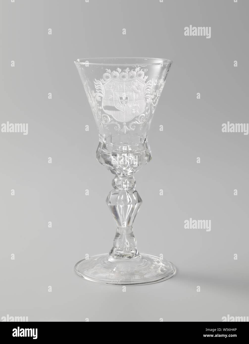 Wine glass with the arms of William IV Cup with the arms of Willem IV, Flat base with folded edge. Faceted, baluster-shaped trunk with two knots and a tear. Bell-shaped cup with a facet-cut underside. On the chalice, among tendrils, the coat of arms of Stadholder Prince William IV (1711-1751) crowned with five sunflowers. On the reverse of the glass the inscription: VIVAT // W.C.H. FRISO. PRINSE. // STADH. CAPT & ADM. // GENER, coat of arms (symbol of sovereignty), William IV (Prince of Orange-Nassau), anonymous, c. 1730 - c. 1750, glass, glassblowing, h 17.0 cm × d 8.3 cm Stock Photo