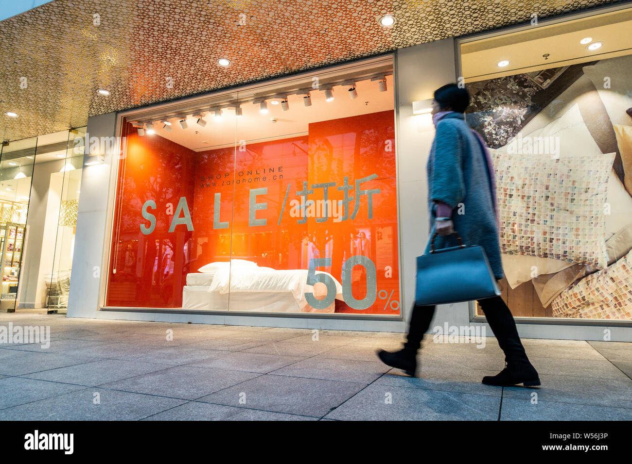 FILE--A pedestrian walks past a signboard of Sale at a store of ZARA HOME  in Shanghai, China, 27 December 2018. International fashion brand Zara h  Stock Photo - Alamy