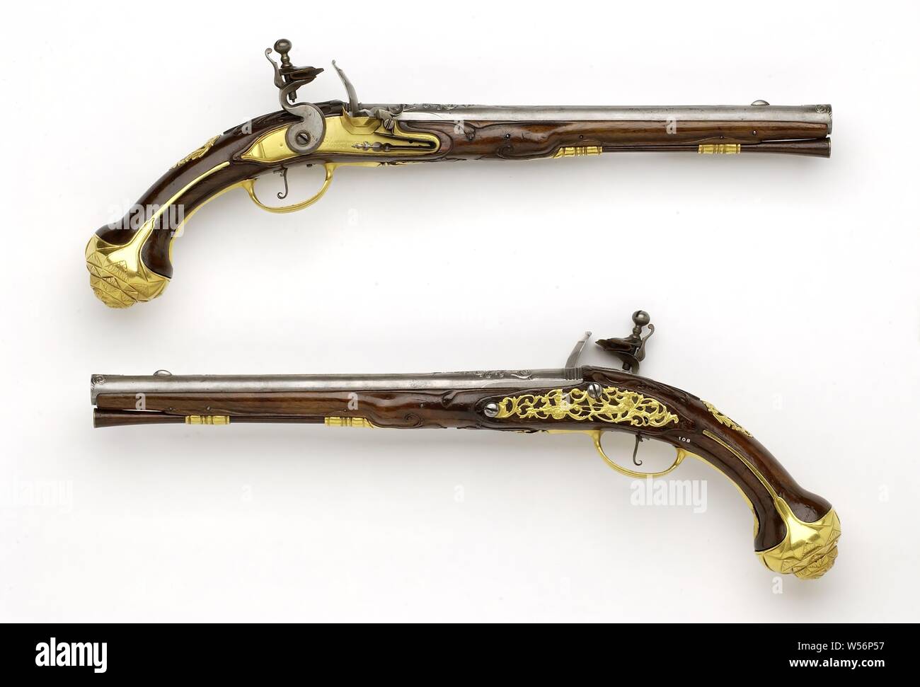 Flint gun, Part of a couple. The gold-plated, copper-plated lock plate is engraved with a signature, the rooster is made of iron, the steel spring blued. The barrel has a round cross section and a series of octagonal rings on the back, a ridge runs between the breech and the iron visor grain, marked on the back with the arms of Utrecht and on the bottom with a crowned coat of arms. The flask has been cut with, among other things, accolade. The gilt brass fittings consist of, a screw plate with ajour worked leaves, one of which ends in a dragon, and a female figure with a short axis on a Stock Photo