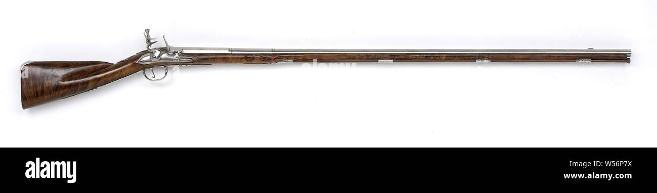 Flint hunting rifle, The lock plate is undecorated except for a signature. The barrel has two rings, the visor grain is made of iron, stamped at the bottom with an unrecognizable stamp and the arms of Utrecht, the arms of Utrecht are also stamped on top. The drawer of burr walnut is simply carved with, among other things, chic work. The iron fittings consist of, among others, four loading rod tubes, an open-worked screw plate with two hoses and lofwork, and the open-worked thumb plate with grotesque masks, leaf scrolls and a shield engraved with the initials E: C: P: D: N: S: above the year Stock Photo