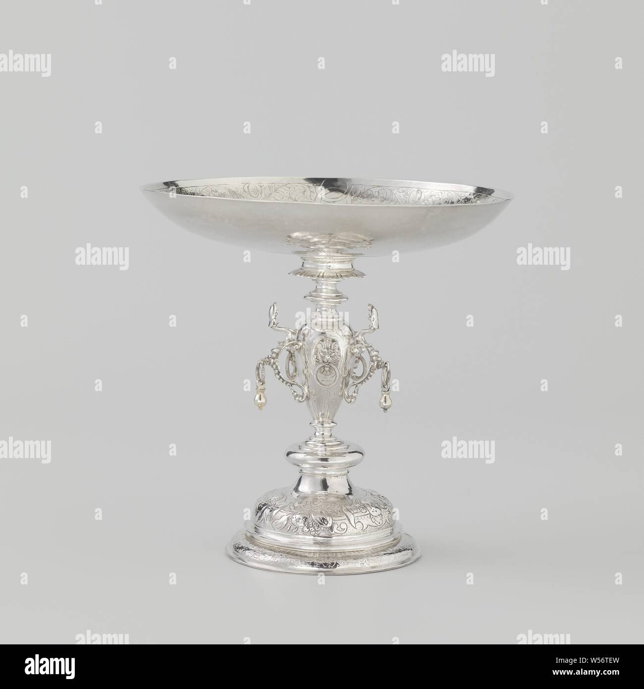 Tazza Drinking bowl with four regents from the Burgerweeshuis in Amsterdam, Drinking bowl on base of driven silver. Three volute-shaped dragons are attached to the trunk. The basin is engraved with bandwork, tendrils and birds. Along a medallion is an inscription., Banquet or elegant company, ornament derived from plant forms, Burgerweeshuis (Amsterdam), anonymous, Amsterdam, 1635, silver (metal), h 18 cm × d 18 cm × w 258 Stock Photo