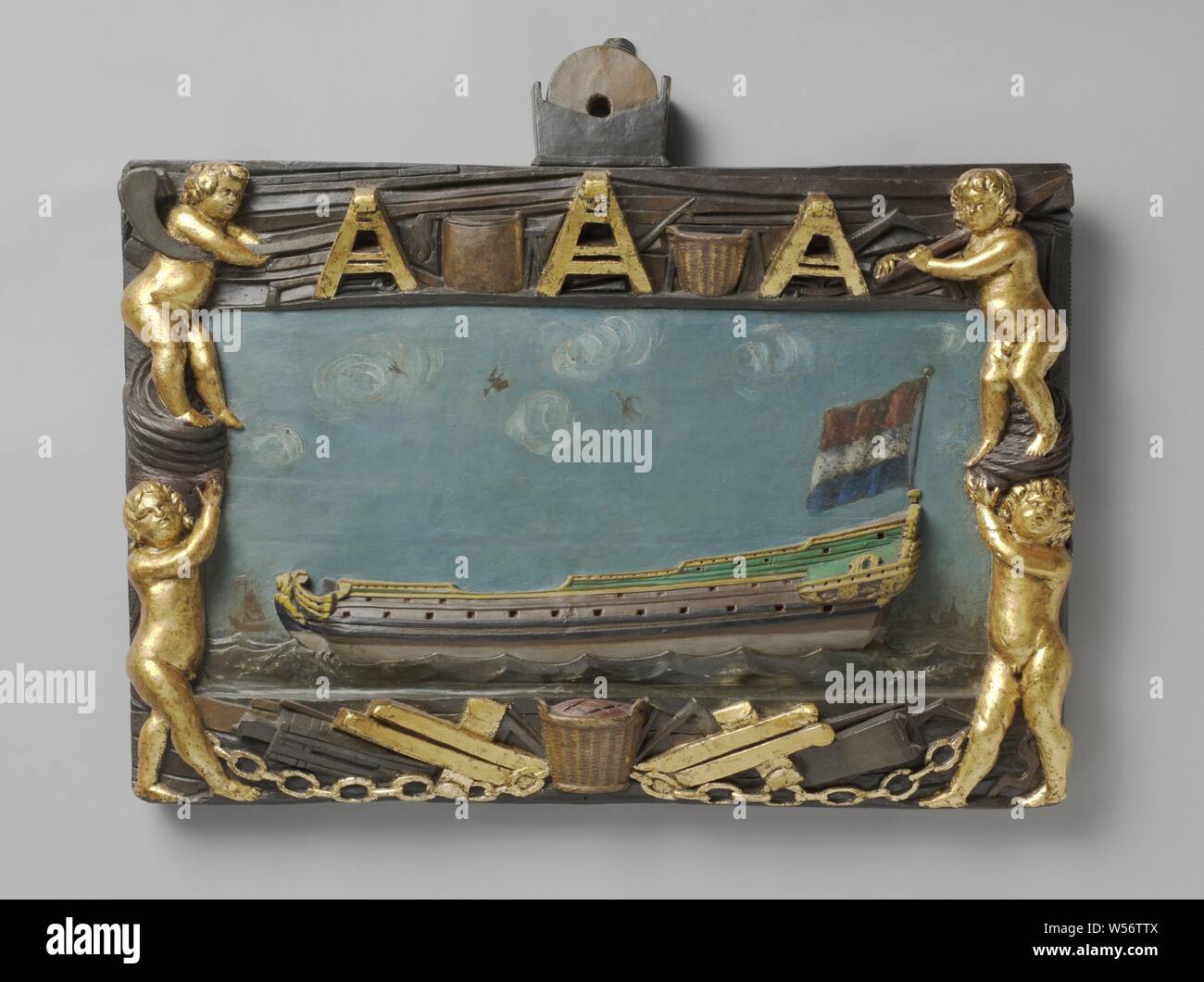Sign of a Shipyard, sign with an image of a ship's hull. The signboard is probably from a shipyard or from the ship's carpenter's guild. The cut ship's hull is surrounded by four cupids and various professional attributes. The whole depends on a sharpening stone., Shipbuilding industry, anonymous, Netherlands, 1600 - 1699, wood (plant material), h 62.5 cm × w 76 cm × d 8 cm Stock Photo