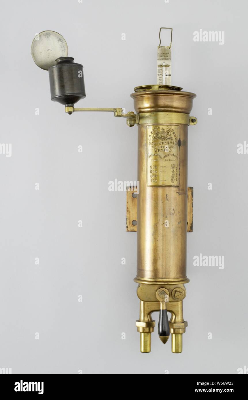 Salinometer, incomplete. It consists of a heavy copper tube or barrel with two pipes at the bottom. One pipe has a tap and serves as the boiler water supply, the vessel is filled and the excess water runs out of the vessel via an overflow to the second pipe. This makes it possible to measure a constant flow of boiler water, to determine an average. After the measurement, the water remaining in the vessel can be drained to the drain pipe by means of a second tap. A brass cylinder for the hydrometer (missing) and a thermometer are fitted in the vessel itself. A light and a round reflection Stock Photo