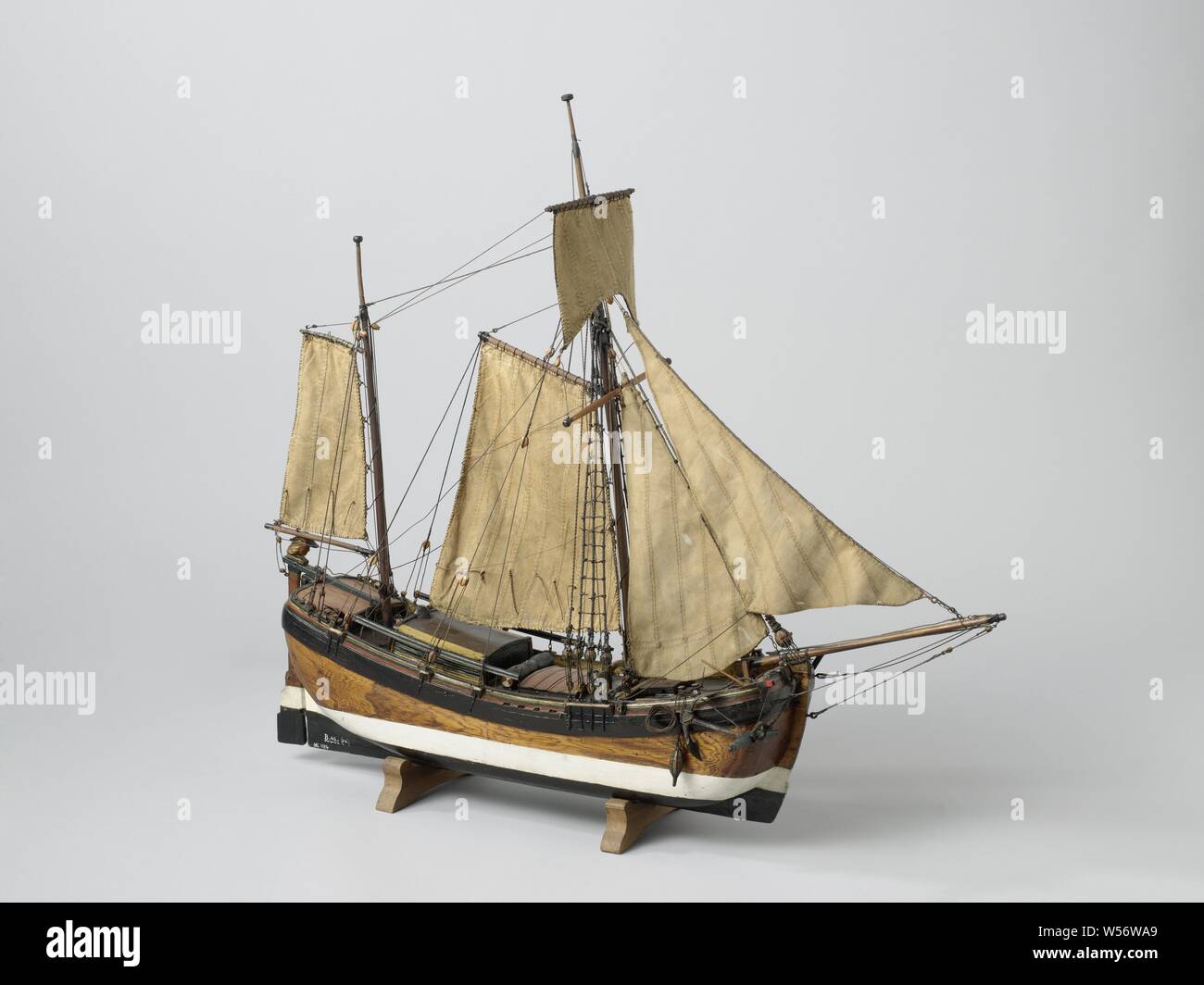 Model of a coffe, Model of a Koff, Witnessed and polychromed block model of a two-mast coffe. The model has one main deck with shutters, and behind a sunken cabin with a campaign deck on top. Flat bow with curved bow, round stern with two ports. Long straight rudder with rudder head in the shape of a human head with hat, tiller over the campaign deck. The model is equipped with an anchor, a roasting spindle, three tons, a pump and a guard rail. The sheer comes up and eight, a wide bar wood is indicated. Peaked spans, the underwater ship is dyed dark blue with a wide white waterline. The model Stock Photo