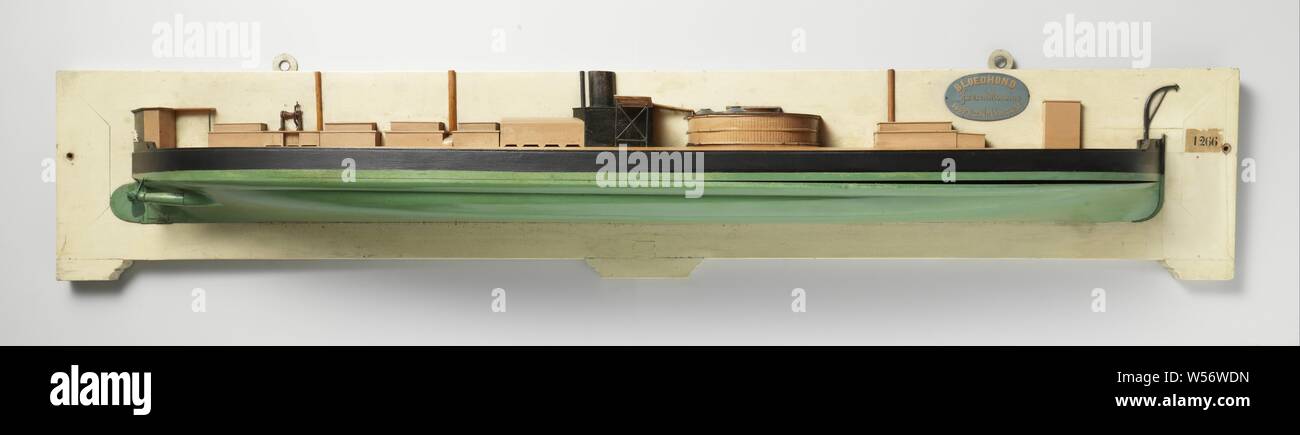 Half Model of a Monitor, Polychromed half model (starboard) and block model of a monitor. It has a vertical prow with chicken strut, a sharp aft ship, rudder with rounded rudder blade, a propeller shaft of a pair, the propeller is missing. The original gun turret is missing, on deck ten narrow deckhouses and cupboards: on the deck superstructure just behind the dome a bridge with gratings and a chimney. On a deck superstructure behind the steering wheel. Three masts are indicated. The sheer is completely flat, the hull shape is a flat bottom. 1:40 scale (derived)., Rijkswerf Amsterdam Stock Photo