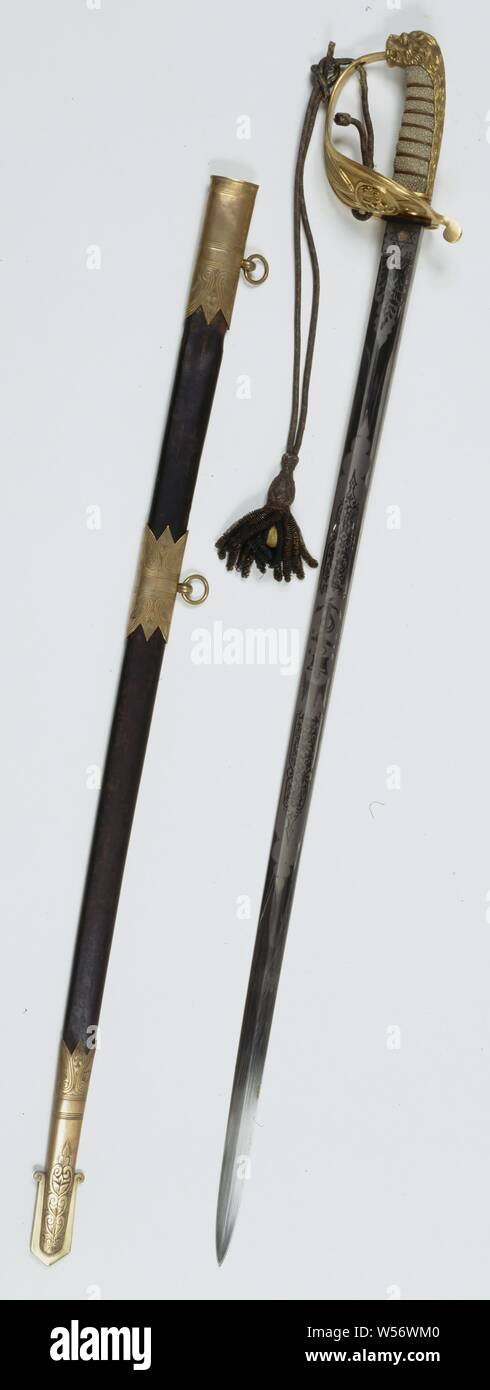 British Naval Sword in Scabbard, English saber with scabbard. Slightly curved sable blade with broad blood channel and back section without heel (Wilkinson blade), it is etched with leaf motifs, on one side a crowned unfinished anchor, on the other the British royal coat of arms. It bears the inscription and a test mark. The sword has a white-shark-coated handle wrapped in copper wire, a closed hilt with a crowned unfinished anchor, and a lion-shaped knob. The private part of the baffle plate can fold down and then close with a hole on a cam of the sheath. A blue and gold galon saber brush Stock Photo