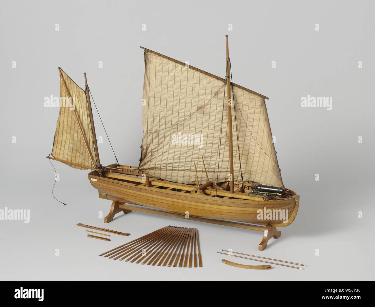 Model of an Armed Longboat, Tested truss model on a standard. Smooth-edged double-belted barkas, round truss with almost flat sheer and flat mirror, a forecourt, nine diets and eight rails and an open cabin with side dents. Midships a roasting spindle including a tapered square wooden tube with a hole through the skin: heavy anchors were lifted. The prow is coppered and has a disk. Three-part frames. Simple rudder with a tiller that fits over the rudder king. The rig consists of a large logger sail and a sprit sail with parrot pole as a drip. The bottom carriage of the carronade consists Stock Photo