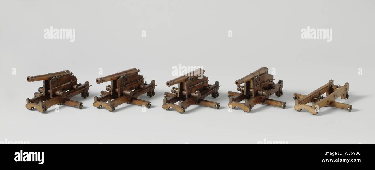 Five Models of Guns on Slides and Pivots of a Coastal Battery, Five models of guns on turn slides, of a coastal battery, one of which is incomplete. The slides consist of a rectangular frame with brass fittings, the beams in the longitudinal direction with upward ends, lying on a long crossbar in the middle, the spindle bolt is fitted in the middle of this crossbar. By screwing it through the beam, the spout is lifted onto the spindle bolt. The frames have wheels at the corners and ends of the crossbar, the axes of which are radial to the spindle bolt. The upper chaffs consist of two cheeks Stock Photo