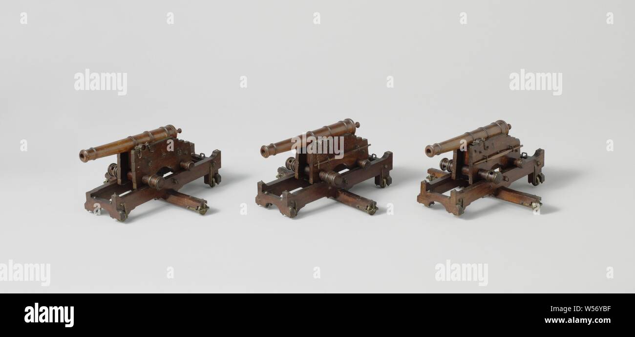 Three Models of Guns on Slides and Pivots of a Coastal Battery, Three models of guns on turn slides, of a coastal battery, incomplete The slides consist of a rectangular frame with brass fittings, the beams in the longitudinal direction with upward ends, lying on a long crossbar in the middle, the spindle bolt is fitted in the middle of this crossbar. By screwing it through the beam, the spout is lifted onto the spindle bolt. The frames have wheels at the corners and ends of the crossbar, the axes of which are radial to the spindle bolt. The upper chaffs consist of two cheeks with three steps Stock Photo