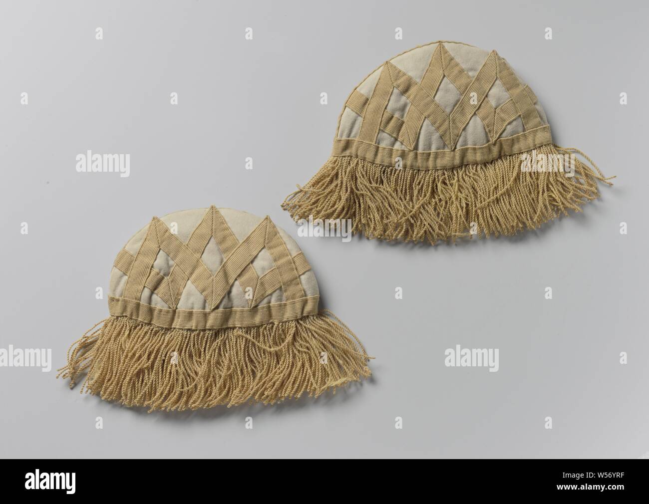 Pair of swallow nests for drums, pipers, horn blowers of the national infantry, horn blowers of the national infantry. A semicircular white cloth shoulder cover, set off with faded yellow galons, ditto crossed galons on the white cloth. Outside model blue gray lining (quilted). Damaged yellow frills, Netherlands, anonymous, c. 1825, cloth, wool, linen (material), w 45.5 cm × h 7.5 cm × d 33 cm l 10 cm × w 17 cm l 6.5 cm × w 19 cm Stock Photo