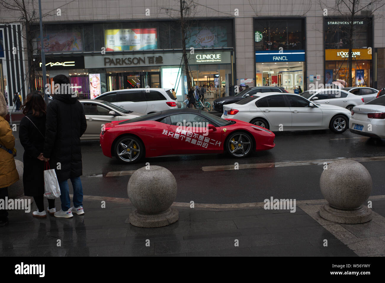 A food store owner drives a luxury Ferrari sports car to deliver meals to customers in downtown Chengdu city, southwest China's Sichuan province, 24 F Stock Photo