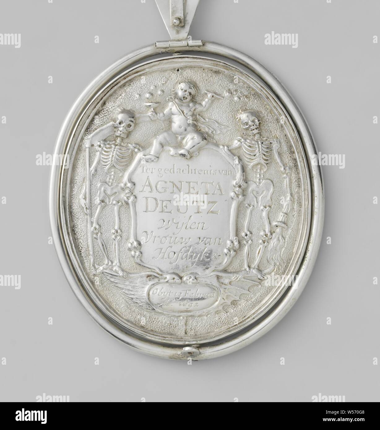 Death of Agneta Deutz, Lady of Hofdijk, Medal or plaque of silver, made on the occasion of the death of Agneta Deutz, Lady of Hofeijk, enclosed in a metal ring, with a tripod with a hinge around the token being able to stand upright, at the bottom of the ring to attach the crossbar to the tag. Obverse: woman lying on sarcophagus, decorated with cartouche with inscription: MRS AGNETA DEUTZ GIVES HER SPIRIT TO GOD. ON 'T GRAF IT'S DAMAGED BODY SURPLUS. BUT HER HISTORY IS THIS SILVRE ART. TO THOSE RECEIVING THIS THANKS FROM HER FAVOR. Above that, two angels with banderolle lit up float through Stock Photo