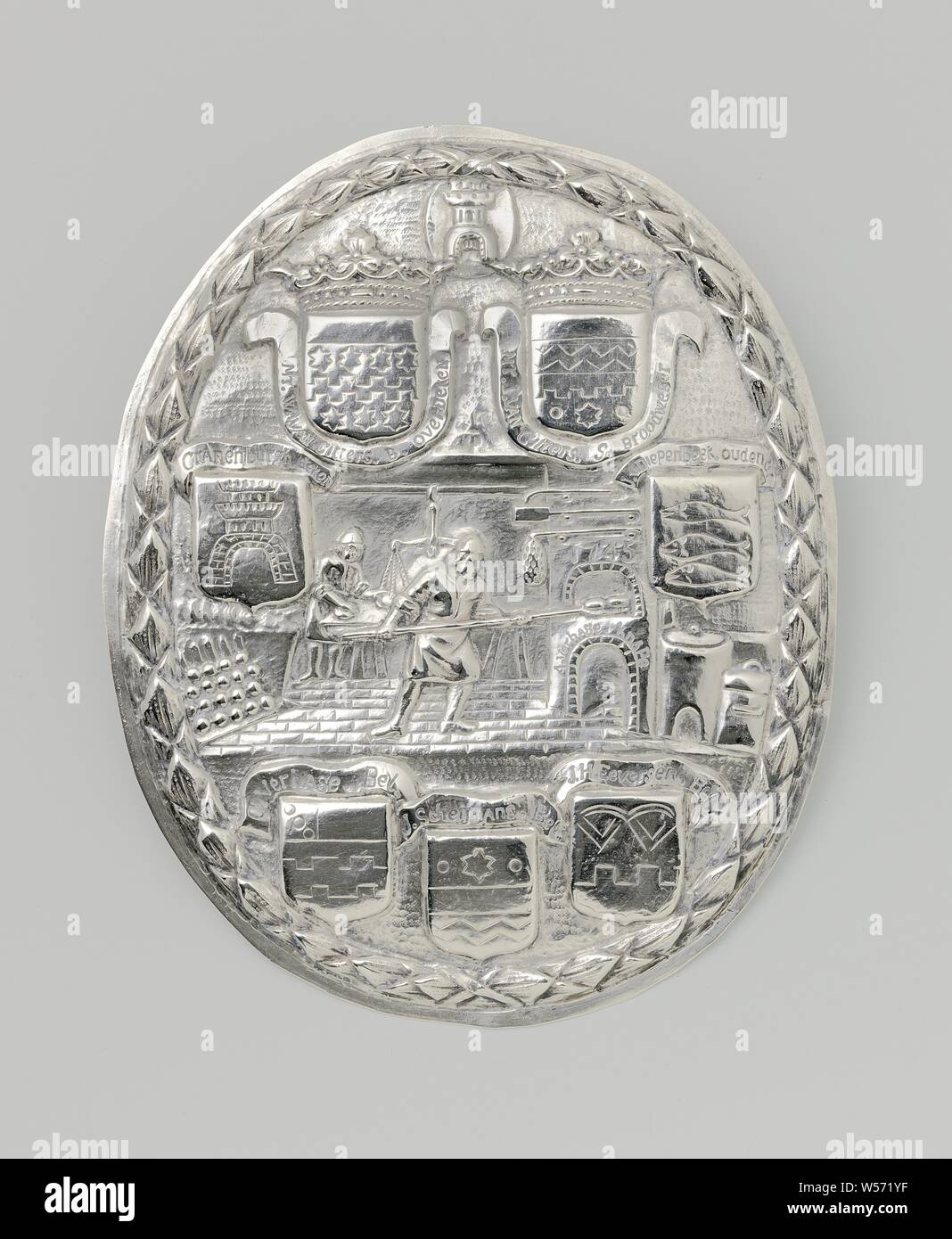 Oval silver shield of the baker's guild in Middelburg, Shield of the baker's guild in Middelburg. Oval, with a passionate depiction: in the middle a baker at his oven, behind him a boy with scales. Seven coats of arms with bindings with names. Two crowned weapons (Van Citters) and weapons from Cranenburch and Van Diepenbeek and three shields with the names Verhage, Scheymans and Eversen. On the oven, including 1745. On top of the shield the coat of arms of Middelburg. The whole is surrounded by a leaf wreath. Not marked, Middelburg, anonymous, 1745, silver (metal), h 17.4 cm × w 14.1 cm Stock Photo